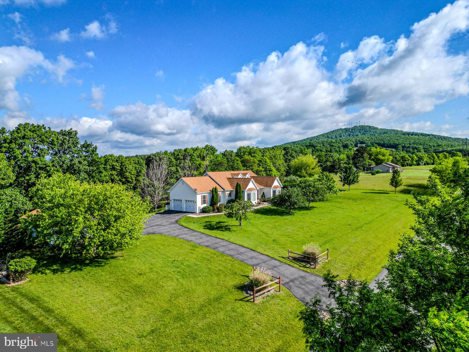 Perched on 4.16 acres in the scenic and sought-after Orchard View Estates, this stunning 3-bedroom, 3-bath Cape Cod-style home offers space, style, and panoramic views that stretch for miles. With nearly 3,000 square feet of finished living space, every corner of this home has been thoughtfully crafted for both comfort and function.
Step inside to a bright and open kitchen and dining area, where tile floors, stainless steel appliances, and a large walk-in pantry make everyday living feel effortless. From the dining room’s oversized window, take in long-range views of the rolling mountains—your daily reminder of the beauty that surrounds you. Off the attached garage, a dedicated laundry room adds convenience with built-in shelving, a laundry sink, and included washer and dryer.
The main level features hardwood floors in the living room and plush carpeting in each of the bedrooms. The spacious primary suite includes two oversized closets, a tray ceiling, and a spa-inspired bathroom complete with double sinks, a jetted soaking tub, and a separate tiled shower.
The finished walkout basement is a true bonus—fully carpeted and ready for anything you dream up. A built-in wet bar with a sink, refrigerator, and counter space makes this the perfect hangout zone, second living room, or home theater space.
Outside, the lifestyle continues. A large covered back deck is ideal for morning coffee or sunset dinners, and the finished sunroom invites you to relax year-round, no matter the weather. The property includes an attached two-car garage plus a detached one-bay garage outfitted with electric, propane heat, and a 30-amp plug for RV or EV charging. It's currently used as a home gym, but the options are endless.
Love to garden? You’ll find a large, productive space ready to go, along with mature apple, peach, and pear trees and established grapevines. A slab is already in place if you’d like to add a hot tub, and the included storage shed provides extra room for tools and toys.
Located just five minutes from local shopping, groceries, and gas, you're also only 20 minutes from Moorefield, 50 minutes from Blackwater Falls and Dolly Sods, and just over an hour to Winchester, VA. Whether you're looking for a forever home, a mountain retreat, or a mix of both—this one checks all the boxes.
Schedule your private showing today and come experience the peace, space, and possibilities that this beautiful West Virginia home has to offer.