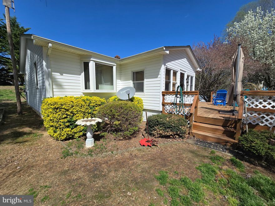 This house on a hill has benefited from years of TLC.  Serene front deck leads to an enclosed front porch.  Enter into the eat-in Kitchen or the Living room with built-in custom shelving.  Two bedrooms and bath on this main level.  Stairs lead to the lower level with an office/3rd bedroom (egress window is small by today's standard), a family room and a thoughtfully designed bath/ laundry combination.  Also  an entrance from the driveway into the lower level.  Over sized 2 car detached Garage.