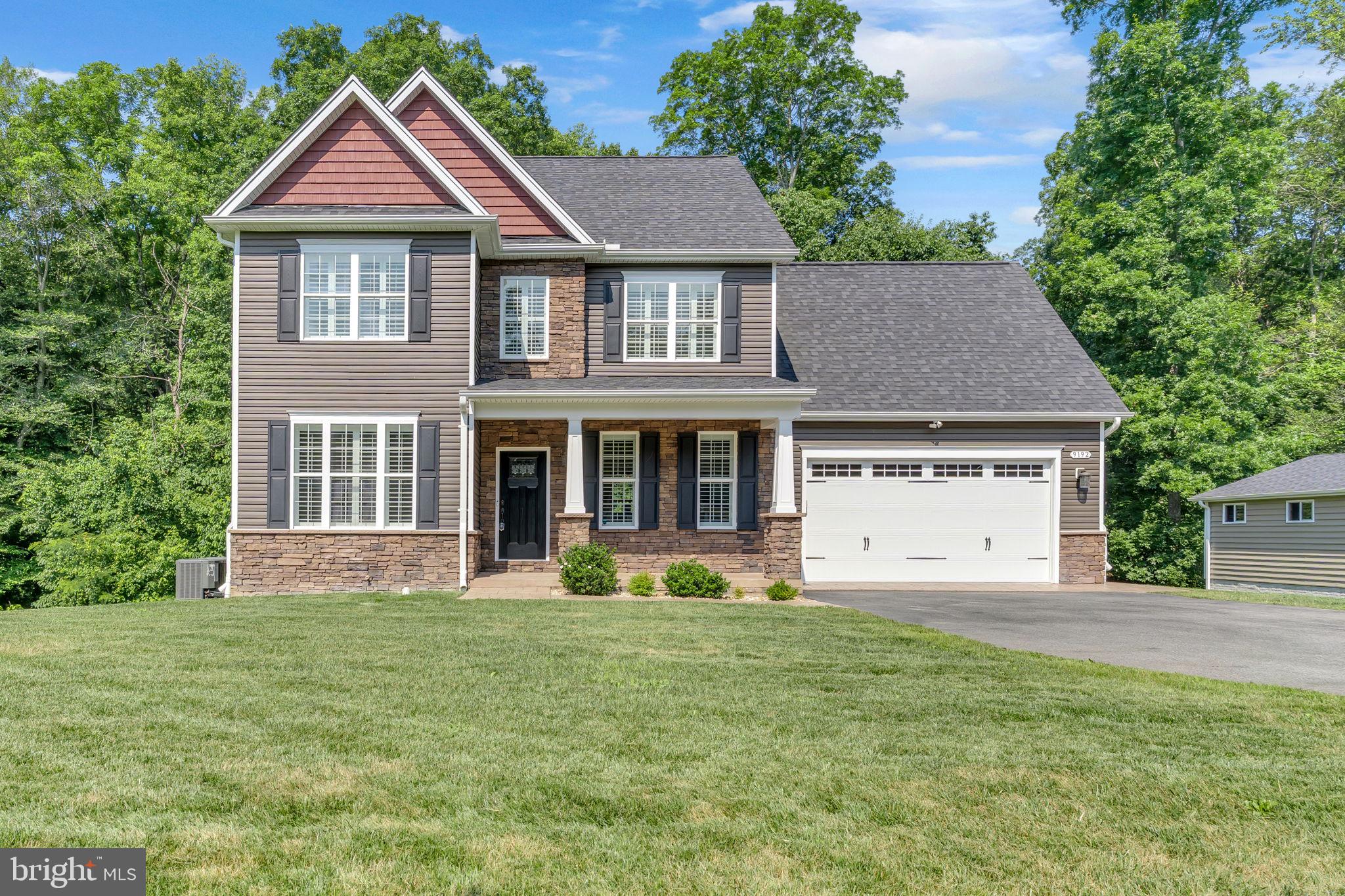 Welcome to this 5 YEAR YOUNG former builder’s model home with exceptional living space, thoughtful upgrades, and refined finishes throughout. Step inside to rich hardwood floors that flow across the entire main level. The foyer is accented by upgraded trim, crown molding, and wide casings. Just off the entry, a private office features hardwood floors, a large window, and a decorative light fixture. The powder room includes a wood accent wall, oval mirror, and designer lighting. The formal dining room is dressed with chair rail and crown molding. The heart of the home is the gourmet kitchen—complete with 42” raised-panel cabinetry, designer granite counters, glass tile backsplash, and smoked stainless steel appliances. Pendant and recessed lights illuminate the breakfast bar with seating for four. The kitchen opens to a breakfast nook with large windows and a decorative chandelier, and the spacious family room features a gas fireplace with marble surround and a designer ceiling fan. Remote-controlled blinds enhance comfort and convenience. Upstairs are four generously sized bedrooms, each with closet organizers. The spacious owner’s suite offers a large walk-in closet and a luxurious en-suite bath with a soaking tub, dual sink vanity, floor-to-ceiling tiled shower, and tile flooring. The hall bath includes a raised double vanity, tub/shower combo, and shiny plank-style tile. The upper-level laundry closet is conveniently located, and an additional cabinet and counter provide a perfect folding station or desk area. The fully finished walk-out basement includes a large recreation room, a full bath and a versatile bonus room perfect for a gym, theater, or playroom. A sliding glass door opens to a patio beneath the deck. Three additional electrical circuits were added for future outdoor expansion. Dual-zone HVAC, Ecobee smart thermostats, fire sprinklers, and an electric water heater support efficient living. Outdoor living is just as impressive. Enjoy a large, maintenance-free deck with a vaulted screened-in porch (approx. 20’ x 12’) featuring a ceiling fan, upgraded outlets (including one for a TV), and vinyl railings. An additional 10’ x 12’ open deck area adds flexibility. The rear yard backs to woods for added privacy. The exterior includes stone and vinyl siding, a stamped concrete walkway, and an asphalt driveway with overflow parking for two. The finished garage features overhead storage, cabinetry, and a side access door. A 9-zone irrigation system covers the entire yard. Simply a must see.