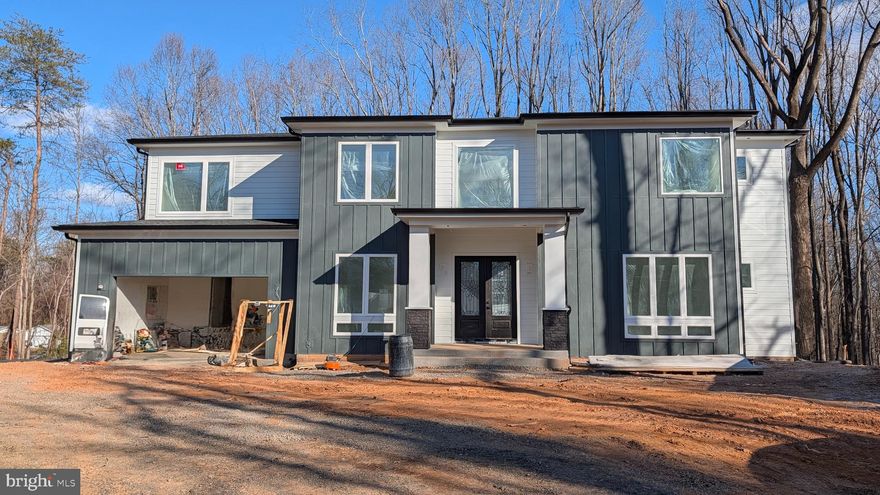 UNDER CONSTRUCTION: Sleek Modern Custom Home with Luxury Finishes in Manassas – Estimated Delivery  Late February 2026!
Builder is offering a $10,000 closing cost credit, plus an additional 0.50% of the loan amount when using the preferred lender and title company. 
Buyers who ratify by November will still have the opportunity to customize interior finishes, giving you a rare chance to personalize your dream home before construction progresses too far.

Get ready to fall in love with this expanded version of our highly popular model, offering even more space and flexibility across three beautifully designed levels. Nestled on a 1.17-acre corner lot, this approximately 5,800 sq ft, 6-bedroom, 6.5-bathroom modern masterpiece blends luxurious finishes with thoughtful design, perfect for today's lifestyle.

As you enter through the impressive two-story foyer, you'll immediately notice the natural light pouring in through oversized casement and picture windows, highlighting the soaring ceilings—10 feet on the main level, 9 feet upstairs, and 9 feet in the walkout basement—creating a truly grand and airy feel throughout.

The expansive main level features a guest bedroom with a private full bathroom, along with a separate powder room for guests. At the heart of the home is a stunning two-story great room, anchored by massive picture windows and a sleek modern fireplace that makes a true architectural statement. The adjacent gourmet kitchen is a showstopper, designed with both style and function in mind, featuring top-tier ZLINE appliances—including a 36” gas range and oven, 48” professional-grade range hood, and stainless dishwasher and microwave—or comparable high-end models to ensure the highest quality. A large waterfall island adorned with Calacatta Quartz countertops, a farmhouse-style sink, and 42” maple Vita white shaker cabinets with transom uppers complete the kitchen’s magazine-worthy look.

Upstairs, the luxurious layout continues with four generously sized bedrooms, each offering en-suite bathrooms for ultimate comfort and privacy. The primary suite is a true retreat, boasting a spa-inspired bathroom complete with a freestanding tub, elegant dual vanities, and a frameless glass shower with dual rain showerheads—the perfect place to unwind.

The finished basement adds even more flexibility, featuring a sixth bedroom and full bathroom, ideal for guests, extended family, or creating a future media room, gym, or office. With the expanded floorplan offering approximately 400 additional square feet compared to the previous build, every level of this home feels spacious, open, and thoughtfully designed.

Step outside to a covered 20’x18’ Trex deck with sleek steel railing, providing the perfect spot for morning coffee, evening wine, or entertaining guests. Built with durable Hardie Plank siding and PVC trim, the exterior is designed for both beauty and low maintenance for years to come.

This home offers a rare combination of modern luxury and custom craftsmanship, all within easy reach of major commuter routes and the charming Historic Town of Clifton. Whether you are searching for everyday elegance or a stunning forever home, this property will exceed your expectations.

Disclaimer: Photos are from a previously completed home of a similar model. Finishes, selections, features, and options may vary in the final construction. Please consult the listing agent for details.