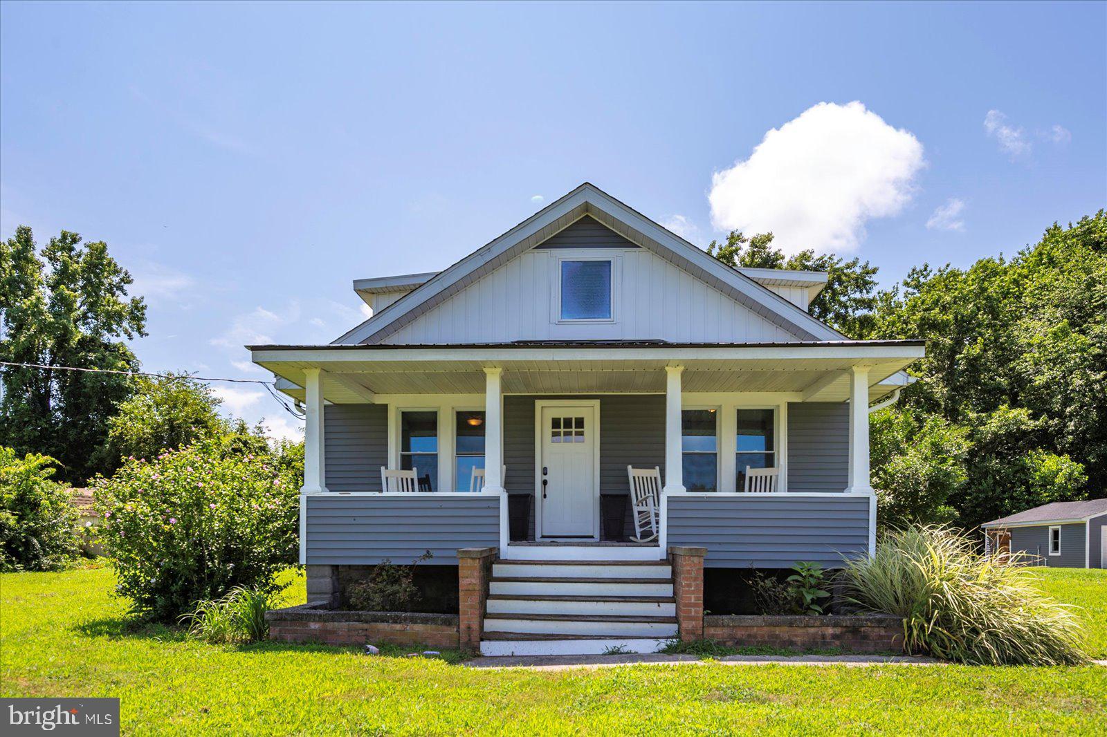 This adorable completely renovated farmhouse sits on 2 acres in a country setting, yet minutes from both the beach and downtown Berlin, without the town taxes. The first floor features an updated kitchen with granite countertops and stainless appliances, an open living area, 2 bedrooms, a full bathroom and laundry closet with a barn door accent. Upstairs is a bright sunlit private primary suite with full tiled bathroom. There is a back deck off of the kitchen and a cute and cozy front porch for relaxing and looking down from the top of a hill across fields. A detached garage offers the option of storage space, a workshop or parking while a full basement offers additional storage. This could be the perfect home for those looking for a quiet private setting with acreage that is a convenient distance to Ocean City, downtown Berlin and Delaware.