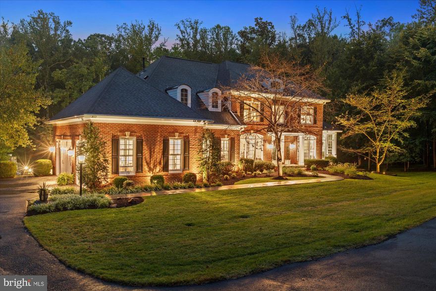 An exceptional private estate tucked away on an expansive 3-acre lot in one of Woodbridge’s most desirable enclaves. Perfectly positioned just a short walk from the scenic Occoquan River, this estate offers a rare combination of serene nature views, resort-style amenities, and an elevated interior design.

From the moment you arrive, the estate's grandeur is undeniable. The circular driveway with brick columns and lighting create a grand entrance and lead to the redesigned front portico with black standing seam hip roof and square columns. A slate walkway, flagstone accent walls and uplighting on the home and trees along the driveway add to the refined exterior. The lot has been professionally landscaped and offers mature trees, flowering shrubs, and seasonal plantings and includes a 21-zone lawn irrigation system for effortless maintenance.

A breathtaking foyer sets the tone for the elegance found throughout the home. Three-piece crown molding decorate the main areas and a built-in sound system add to the luxury. The kitchen is every chef and host's dream, with an upgraded gas cooktop and range hood, stainless steel appliances, expansive island with beverage cooler and ample space throughout for the host and guests alike. A main-level master suite offers flexibility and convenience for one-level living. Main-level laundry room includes new cabinets, granite-topped sink, decorative paneling, and a plantation-shuttered window.

As you ascend the grand staircase, you're greeted by beautiful hardwood flooring, accentuated by a decorative inlaid medallion that adds a touch of elegance and sophistication. The journey leads you to the upper-level primary suite, a luxurious haven where every detail is meticulously crafted to offer comfort and style. Here, the enhancements are numerous, starting with a tray ceiling that boasts intricate molding and recessed lighting, creating a warm and inviting ambiance.

The serene views from the primary suite are truly breathtaking, offering a picturesque overlook of the sparkling pool below. Imagine waking up each morning to the gentle shimmer of water reflecting the soft morning light, or unwinding in the evening with the tranquil sight of the pool under a starlit sky. The seamless shower glass panels in the suite's bathroom add to the sense of openness and continuity with the outdoors, while an added linen closet ensures ample storage for all your needs.

Plantation shutters provide not only privacy but also precise control over the natural light that floods the room. Whether you prefer the suite bathed in the gentle glow of the sun or cloaked in serene tranquility, these shutters offer the flexibility to create your ideal environment.

The upper level is thoughtfully designed to offer both privacy and comfort, featuring a secondary staircase that provides convenient access to this serene enclave. In addition to the luxurious primary suite, the upper level boasts three additional bedrooms, each equipped with its own en-suite bathroom. These well-appointed bedrooms provide ample space and privacy for family members or guests, ensuring everyone enjoys their own personal retreat. The en-suites are designed with modern elegance in mind, complete with high-end fixtures and finishes that enhance the overall sense of luxury on this level.

The fully finished lower level is a masterpiece of comfort and entertainment, offering a luxurious retreat within your home. It features a spacious king bedroom suite, complete with a generous closet, an inviting sitting area, and elegant plantation shutters that provide both privacy and style. The spa bath is a sanctuary of relaxation, boasting a frameless glass shower enclosure with dual entries, ensuring convenience and a touch of opulence.

For the wine connoisseur, a custom wine cellar awaits, adorned with a striking mosaic tile feature wall that adds an artistic flair to your collection. The entertainer's bar is a hub of hospitality, fully equipped with a si