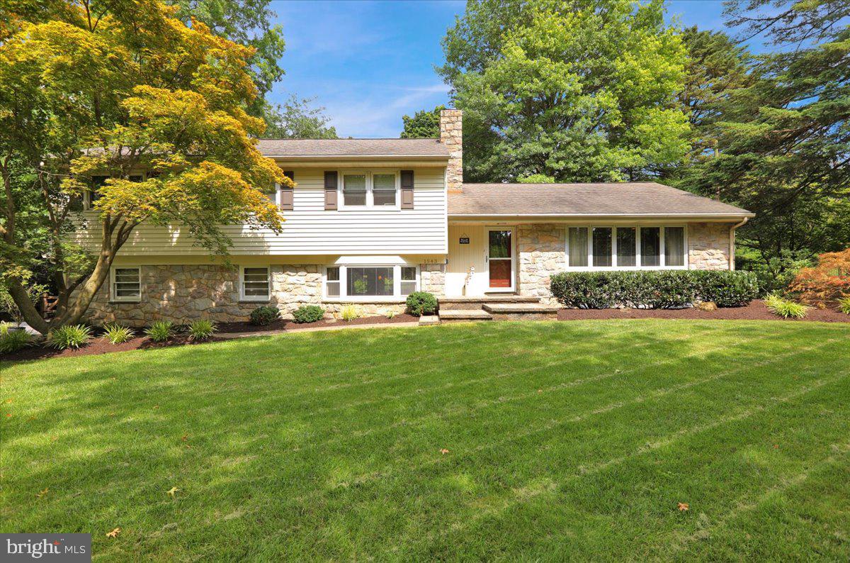 Classic Wyomissing sprawling split-level on a lovely tree-lined street in Birdland is where you’ll find this gem, sitting on a spacious and private .50-acre lot, fully fenced in yard. Surrounded by lush mature landscape and a lighted hardscaped walkway and entrance leading to the front door and extensive hardscaping with multi-level patios all surrounding a stunning heated gunite black-bottom pool in the back yard. This back yard has the 'wow' factor! Inside, you’ll appreciate the classic feel of this home, mingled in with current decor starting with the flagstone tiled entrance and hardwood floors which run throughout the home. The living room is large with a bay window to allow for plenty of natural light and views of the tree-lined street. This opens to a formal dining room, which flows into the kitchen with a back door leading to the pool and grilling area. Up a few steps are 4 very generous sized private bedrooms with the primary bedroom having a full private bathroom. The hall bath is also located on this level. A few steps down is the family room with a gorgeous stone wood burning fireplace, bar area and another door leading out to the pool area. A half bath is close by for a quick trip from the pool, as well as an office and access to the garage. Down one more level is yet another finished off area, perfect for another hangout area or gym area, as it is currently being used. A nice sized storage/laundry room is also located on this level. You'll appreciate the brand-new high efficiency HVAC system and brand-new roof. This home is much larger than it appears from the outside so whether you’re entertaining your guests inside or outside, Christmas parties or pool parties, this is the perfect family / friends gathering spot!