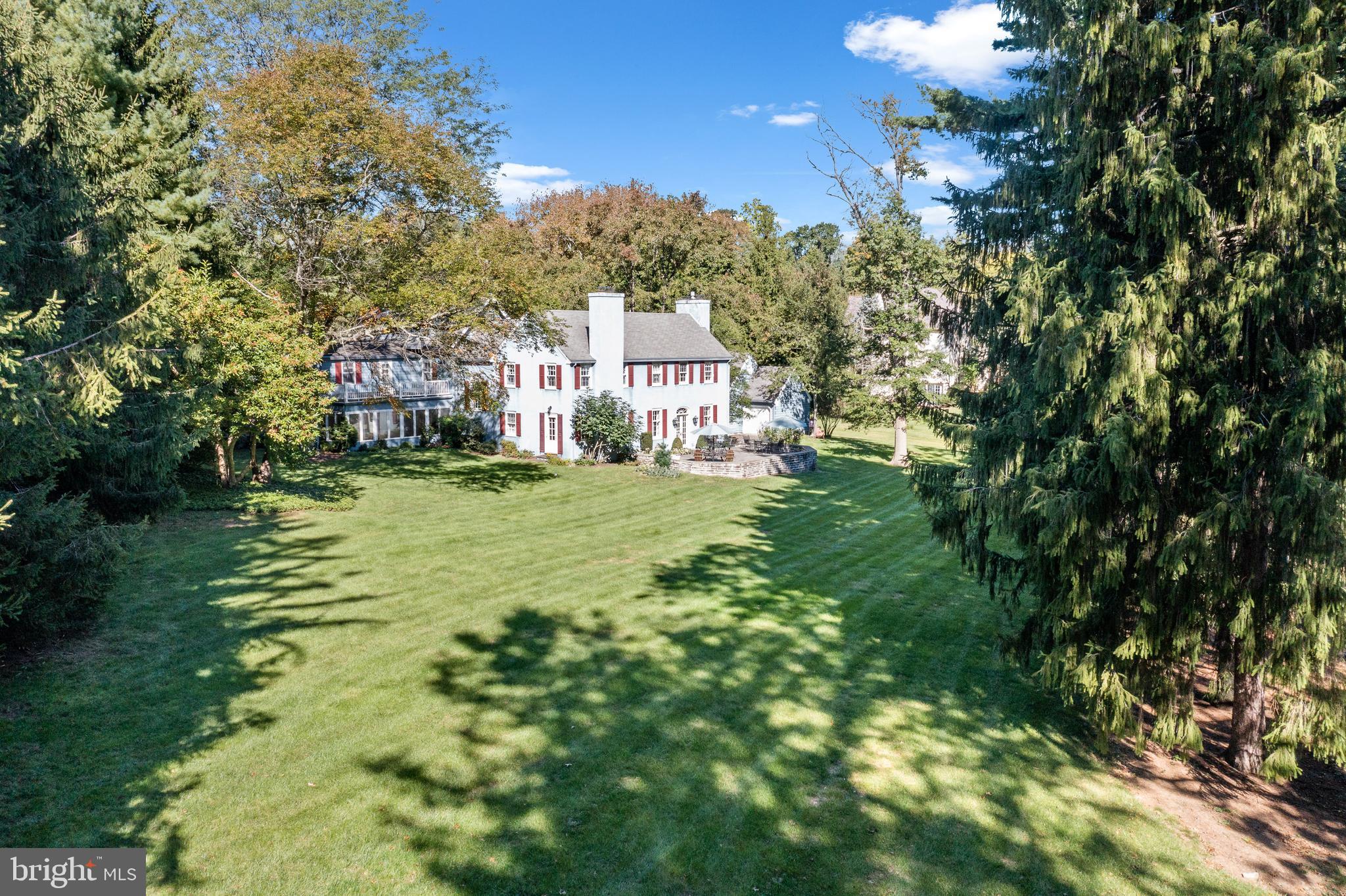 This meticulously maintained, renovated and stately 6/7 bedroom, 5 full/2 half bath home has graced this bucolic 1.64 acres parcel of land since the late 1800s. Located on a quiet cul-de-sac in the center of Radnor Township, and part of Award Winning Radnor Township School District, just minutes from Villanova University, 505 Van Lears Run sits on land first settled by Welsh Quakers in 17th century and later traced to the Cassatt family, one of the most well known Philadelphia families with ties to the Pennsylvania Railroad.
Pull into the Belgium block lined circular driveway and you are welcomed into the gracious foyer, with an oversized eyebrow window, high ceilings and handsome hardwood floors. Natural sunlight floods the house by way of countless windows with deep window sills, bouncing off the gleaming hardwood floors throughout. Each room provides the most exquisite views of flowering trees, lush green grass and wide open space outside. To the left of the foyer is the oversized living room with intricately carved mantle surround and wood burning fireplace, Custom Craft Furniture built-in cabinets, high ceilings and elegant French doors leading to an expansive, flagstone patio overlooking the perfectly manicured grounds. Off the living room you will find the library with a wood burning fireplace, cherry cabinets and shelves and separate outside access. Past the powder room off the wet bar with maple cabinets, granite countertop and a Marvel bar fridge, is a spacious dining room with rich, original hardwood floors, a built-in glass curio and access to the large, bright family/sunroom (also accessed via the kitchen). Back stairs leading to 5 spacious bedrooms on the 2nd floor are located discreetly off of the dining room, just outside the expanded and updated eat-in kitchen redesigned by the current owners in 2000 with ample cherry cabinets by Conestoga Valley and white Corian countertops, double corian built in sink, granite island countertop and top of the line Miele appliances including 5-burner cooktop, two gas ovens, a range hood, as well as a Sub-Zero refrigerator, Bosch dishwasher, and a trash compactor. Radiant floor heating extends from the dining room, to the kitchen, sunroom/family room, mudroom, and laundry room off of the eat-in kitchen area, and the home office complete with a pocket door for additional privacy, featuring custom maple desk and shelving extending the length of the room. Continue up the main staircase from the foyer to the large landing on the second floor leading to the generous sized primary bedroom with hardwood floors, high ceiling, custom closets, built-in bureaus, a gas fireplace, and an updated ensuite bathroom with Italian tumbled marble flooring and radiant heating featuring a double vanity, claw tub and shower. To the right of the primary bedroom is a second bedroom with a wood burning fireplace and a full private bath. Just down the bright, sunny hallway are 2 additional bedrooms, with a Jack and Jill ensuite. Bedroom 5, located at the end of the hallway has a private full bathroom and direct, secure access to a private balcony overlooking the large, flat backyard and period stone wall. Continue up to the 3rd floor and you will find two additional rooms which can be a bedroom and a home gym/additional office space/guest room/au pair suite plus a full bathroom. The 4-car shaker shingle detached garage built in 1991 has a large unfinished loft and electronic car charger outlet. This home has been exceptionally maintained throughout the current ownership including HVAC system replaced by DiFilippo’s Heat and Air Conditioning in 2007; Pella windows in sunroom and office replaced in 2000; Living room French doors replaced by Pella in November 2011; Patio flagstones and wall re-set in June 2017. More updates/information in the documents section. Stucco report available, no areas in need of repair. A premier Villanova neighborhood minutes to R5 train to Philly, I-476/I-95.