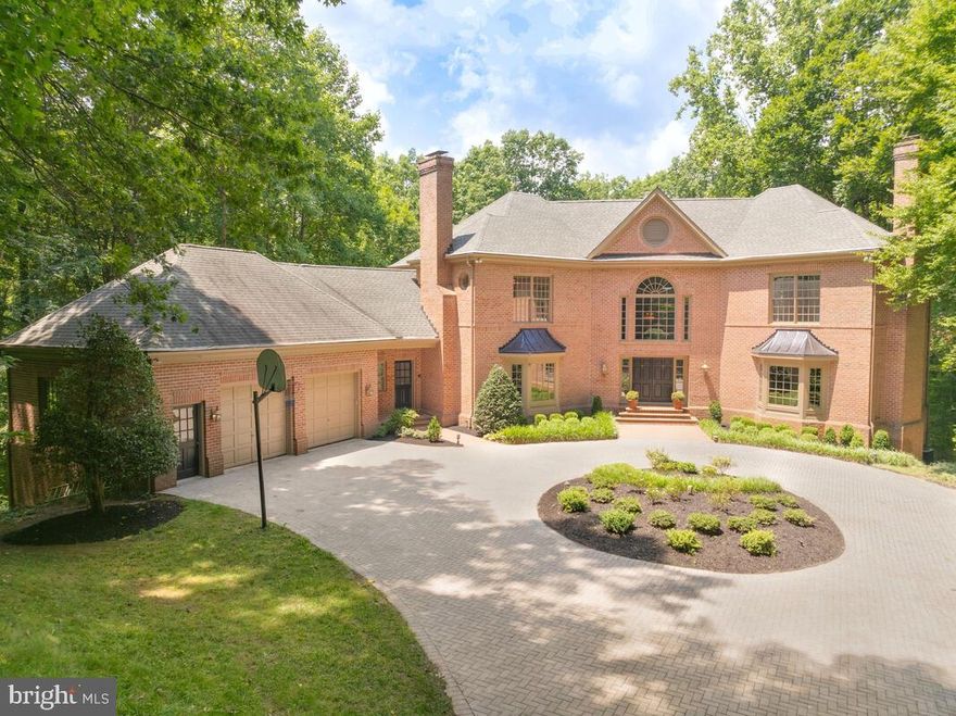 Escape from the world and enter your own modern oasis of spacious tranquility, luxury and ultimate privacy from the moment you approach the elegant gated entrance where trees surround you and the only sound is birds chirping. An iron gate with brick pillars gracefully opens and leads you down the private tree lined drive with landscape lighting. At the end is a stunning paver circular drive and a magnificent 5 bedroom, 5 full and 2 half bath brick Colonial estate! This unique, custom-built home has undergone extensive renovation, with each room updated to offer the latest amenities. It’s a turnkey dream. Expansive windows throughout offer a view of lush woods and reinforce your feeling of natural peace and privacy.  The grand marble tile foyer welcomes you into this extraordinary estate. Quartz counter tops highlight the gourmet kitchen with walk-in pantry, large center cooking island with surround seating, bright, spacious breakfast room and Butler's pantry. Two story ceilings with skylights accent the main level family room with fireplace, giving you the sense of being at home in nature. The formal living and dining rooms both feature beautiful moldings and bow windows. The main level laundry room features a half bath, interior access to the garage and a delivery entrance. The elegant primary suite on the upper level offers a serene and calming setting with propane fireplace, 2 walk-in closets and luxury bath reminiscent of a spa getaway. Opposite the primary is one en-suite bedroom, and two bedrooms that share a Jack and Jill bath and large walk in closets, one being cedar. The lower level is perfect for one who loves to entertain or families seeking spacious and comfortable multigenerational living. A gorgeous built-in full bar offers space for both cocktails and parlor games. A brick fireplace brings warmth to this lower level with gaming area, gym, 2 full bath, bedroom and large room perfect for play or crafts. The lower level opens to a covered patio that leads down to the fenced pool area lush in its surroundings.  The private and secluded backyard oasis surrounds the sparkling inground pool with extensive hardscaping including multiple patio decks. Set on 1.8 acres, this resort-style home has everything you want and more!