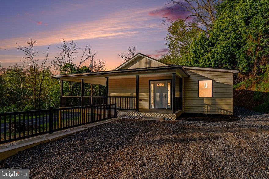 COMPLETELY rebuilt from the inside out, this stunning creek-view retreat blends modern design with peaceful surroundings, all while being located outside of the flood zone! Tucked against a wooded backdrop and overlooking the water, this home offers the kind of setting that feels like a getaway, yet still close enough for everyday convenience. Step onto the expansive wrap around covered front porch and take in the view before heading inside to a bright, open-concept living space featuring soaring ceilings, bold design touches, and a striking floor-to-ceiling fireplace feature wall. The beautifully redesigned kitchen offers white shaker cabinetry, black hardware, stainless steel appliances, solid surface countertops, a farmhouse sink, and a warm butcher block island that anchors the space perfectly. The home has undergone an extensive renovation with major updates throughout, creating peace of mind for the next owner. Improvements include but not limited too - new windows, siding, roof, plumbing, electrical, HVAC, insulation, drywall, flooring, fixtures, kitchen, bathroom, and more. Every detail was thoughtfully selected to create a clean, modern aesthetic while maximizing comfort and functionality.  The property offers a low-maintenance lifestyle with a fresh, modern feel and scenic surroundings. Whether you're looking for a full-time residence, weekend escape, or investment opportunity, this home delivers a unique combination of style, updates, and setting. Enjoy your morning coffee on the porch overlooking the water, evenings by the fire pit, and the simplicity of moving into a home where the hard work has already been done. Schedule your private tour today!