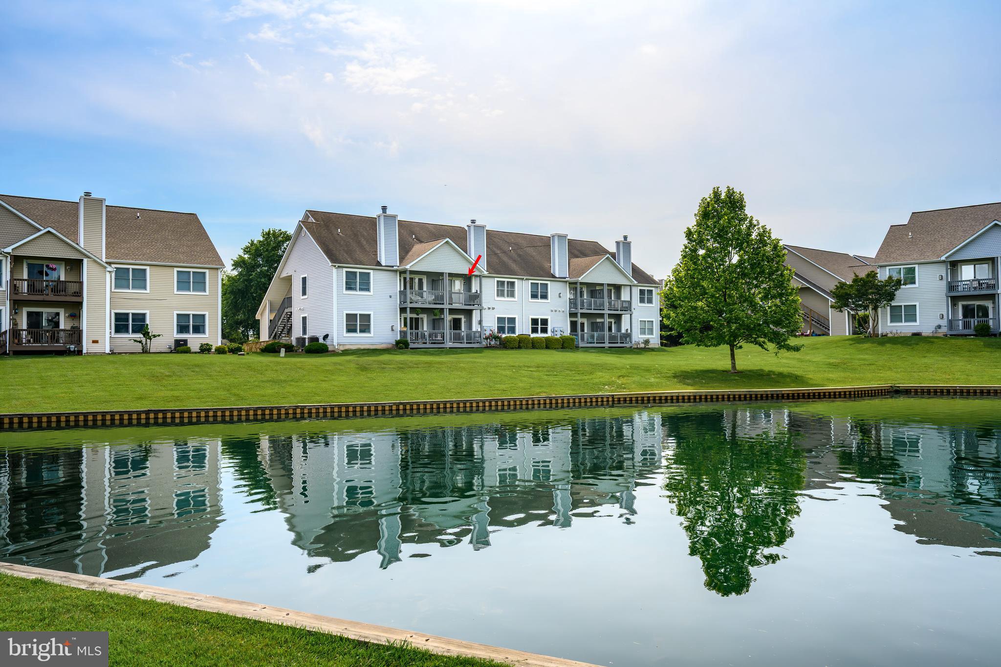 *Experience a getaway lifestyle at this stunning 2nd-floor condominium nestled within the prestigious Bayside Condominium Community. Enjoy peaceful views of the pond and fountain from the private balcony. You will delight in the pond views from the living room, dining and kitchen. The spacious living room features built-ins and seamlessly transitions into the dining area, complete with a sliding glass door leading to the balcony. The kitchen is equipped with a breakfast bar, granite countertops, tile flooring, and stainless steel appliances. The large foyer, living, dining, and hallway areas all feature gleaming hardwood floors, while the two bedrooms have newer carpeting. The expansive primary bedroom includes a full bathroom and walk-in closet. Unwind and enjoy the warm summer months at the community pool and hot tub. The newly renovated clubhouse offers a workout room, balconies with expansive views, a 2nd-floor meeting/party room with kitchen, and a cozy fireplace. For tennis and pickleball enthusiasts, two tennis courts are available. Boat lovers will appreciate the proximity to Castle Marina, offering slips and amenities that provide access to the Chester River, Chesapeake Bay, and beyond. Castle Marina Road also serves as an access point to the Cross Island Trail, from the Chesapeake Bay to the Kent Narrows. It is perfect for nature lovers and those seeking picturesque waterfront spots.