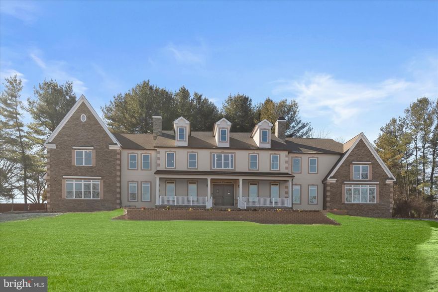 An extraordinary offering of scale, craftsmanship, and innovation, this newly constructed stone and stucco Colonial estate spans an impressive 12,702 square feet and is set on 2.86 acres within a private enclave. Designed for grand living and refined entertaining, the residence is surrounded by mature grounds that yield apples, plums, peaches, cherries, and blueberries each summer, an idyllic and rare natural amenity.  The home features 6 bedrooms, 7 baths, soaring two-story architectural elements, and a thoughtful blend of luxury finishes and smart-home technology throughout. Highlights include multiple entertaining spaces, a private office, a vaulted sunroom with stunning sunrises and sunsets, a winery, a sauna, and a fully equipped home theatre. LVP, tile, and porcelain flooring complement tray and vaulted ceilings, while surround sound, smart toilets, smart laundry, and four-zone climate control elevate everyday living. A stately 8-foot double-entry door with speak-easy styling opens to a dramatic double-height foyer with a grand staircase. The two-story dining room is a true showpiece, showcasing a tray ceiling crafted from reclaimed WWII-era lumber, antique wood planks meticulously milled, de-nailed, kiln-dried, and repurposed as a striking architectural statement. The adjacent two-story family room is anchored by a 51-inch color-changing porcelain-surround electric fireplace, framed by a wall of oversized picture windows, and a custom-crafted mantle.  The chef’s kitchen is designed to impress, featuring a top-of-the-line ZLINE bronze appliance package that includes a 48-inch dual-oven range, pot filler, refrigerator with water filtration, wall oven, microwave, dishwasher, and double sink. A dramatic 72-square-foot island comfortably accommodates banquet- or wedding-sized gatherings, while a coffee, tea, cocoa, and beverage bar, butler’s pantry with wine cooler, and a fully organized pantry enhance functionality. The main level is completed by a living room, private office with French doors and a walk-in closet, a first-floor bedroom retreat with an ensuite bath, a mudroom with built-ins, and access to four individual garage bays.  The vaulted sunroom spans approximately 480 square feet, featuring a 15-foot ceiling with whitewashed wood planks, walls of windows, and French door access, an inviting retreat for year-round enjoyment.  Upstairs, the primary suite is a private sanctuary spanning approximately 1,872 square feet. It features tray and vaulted ceilings, a porcelain electric fireplace, a coffee and beverage bar, three closets, and a spa-inspired marble bath with dual showers, dual vanities, a soaking tub, a linen closet, and a smart toilet. Additional accommodations include an ensuite bedroom with a walk-in closet, a dual entry bath with a soaking tub, a smart laundry room with a GE washer and dryer, and overlook balconies to the foyer, dining room, and great room below.  The finished lower level is dedicated to lifestyle and entertainment, offering a full bar, home theatre, winery, bedroom, and a full bath with sauna. Mechanical systems are equally robust, including dual tankless water heaters, three HVAC systems, three AC units, an in-house sprinkler system, two sump pumps, and a dedicated electrical and mechanical room.  Additional exterior and functional highlights include a 376-square-foot columned front porch, wraparound patio and walkways, a four-car garage with ceiling openers and keypads, two EV charging ports, parking for approximately 15 vehicles, well and natural gas utilities, and an expansive private setting that balances luxury with tranquility.  This one-of-a-kind estate delivers uncompromising quality, exceptional scale, and timeless elegance, crafted for those who seek a truly distinguished residence.  Major commuter routes include MD-32, MD-29, US-40, I-70, and I-95.