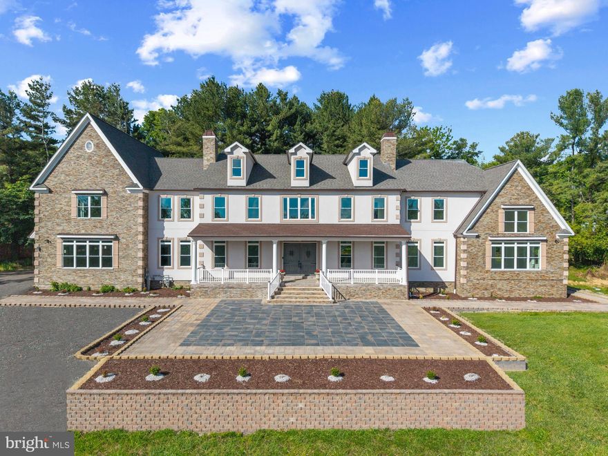 This luxe estate will be sold at Luxury AUCTION Without Reserve on June 30, 2026! List price for REFERENCE ONLY.  Offered in co-op with Platinum Luxury Auctions. Inquire for details. Convenient, Pre-Auction Previews held by appt: June 12-29, 2026. Refer to Luxury Auction Terms of Sale. Call to schedule.
An extraordinary offering of scale, craftsmanship, and innovation, this newly constructed stone and stucco Colonial estate spans an impressive 12,702 square feet and is set on 2.86 acres within a private enclave. Designed for grand living and refined entertaining, the residence is surrounded by mature grounds that yield apples, plums, peaches, cherries, and blueberries each summer, an idyllic and rare natural amenity.  The home features 6 bedrooms, 6.5 baths, soaring two-story architectural elements, and a thoughtful blend of luxury finishes and smart-home technology throughout. Highlights include multiple entertaining spaces, a private office, a vaulted sunroom with stunning sunrises and sunsets, a wine rory, a sauna, and a fully equipped home theatre. LVP, tile, and porcelain flooring complement tray and vaulted ceilings, while surround sound, smart toilets, smart laundry, and four-zone climate control elevate everyday living. A stately 8-foot double-entry door with speak-easy styling opens to a dramatic double-height foyer with a grand staircase. The two-story dining room is a true showpiece, showcasing a tray ceiling crafted from reclaimed WWII-era lumber, antique wood planks meticulously milled, de-nailed, kiln-dried, and repurposed as a striking architectural statement. The adjacent two-story family room is anchored by a 51-inch color-changing porcelain-surround electric fireplace, framed by a wall of oversized picture windows, and a custom-crafted mantle.  The chef’s kitchen is designed to impress, featuring a top-of-the-line ZLINE bronze appliance package that includes a 48-inch dual-oven range with grill, pot filler, wall oven, microwave, dishwasher, and double sink. A dramatic 72-square-foot island comfortably accommodates banquet- or wedding-sized gatherings, while a coffee, tea, cocoa, and beverage bar, a butler’s pantry with wine cooler, and a fully organized pantry enhance functionality. The main level is completed by a living room, private office with French doors and a walk-in closet, a first-floor bedroom retreat with an ensuite bath, a mudroom with built-ins, and access to four individual garage bays.  The vaulted sunroom spans approximately 480 square feet, featuring a 15-foot ceiling with whitewashed wood planks, walls of windows, and French door access, an inviting retreat for year-round enjoyment. Upstairs, the primary suite is a private sanctuary spanning approximately 1,872 square feet. It features tray and vaulted ceilings, a porcelain electric fireplace, a coffee and beverage bar, three closets, and a spa-inspired marble bath with dual showers, dual vanities, a soaking tub, a linen closet, and a smart toilet. Additional accommodations include an ensuite bedroom with a walk-in closet, a dual-entry bath with a soaking tub, a smart laundry room with a GE washer and dryer, and overlook balconies to the foyer, dining room, and great room below. The finished lower level is dedicated to lifestyle and entertainment, offering a full bar, home theatre, winery, bedroom, and a full bath with sauna. Mechanical systems are equally robust, including dual tankless water heaters, three HVAC systems, three AC units, an in-house sprinkler system, two sump pumps, and dedicated electrical and mechanical rooms.  Additional exterior and functional highlights include a 376-square-foot columned front porch, wraparound patio and walkways, a four-car garage with ceiling openers and keypads, two EV charging ports, parking for approximately 15 vehicles, well and natural gas utilities, and an expansive private setting that balances luxury with tranquility. Major commuter routes include MD-32, MD-29, US-40, I-70, and I-95.