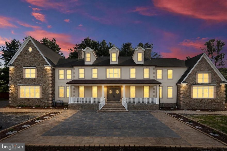 March Madness: The seller is offering a subsidy of 1% towards buyer’s closing costs with acceptable offer.
An extraordinary offering of scale, craftsmanship, and innovation, this newly constructed stone and stucco Colonial estate spans an impressive 12,702 square feet and is set on 2.86 acres within a private enclave. Designed for grand living and refined entertaining, the residence is surrounded by mature grounds that yield apples, plums, peaches, cherries, and blueberries each summer, an idyllic and rare natural amenity.  The home features 6 bedrooms, 7 baths, soaring two-story architectural elements, and a thoughtful blend of luxury finishes and smart-home technology throughout. Highlights include multiple entertaining spaces, a private office, a vaulted sunroom with stunning sunrises and sunsets, a winery, a sauna, and a fully equipped home theatre. LVP, tile, and porcelain flooring complement tray and vaulted ceilings, while surround sound, smart toilets, smart laundry, and four-zone climate control elevate everyday living. A stately 8-foot double-entry door with speak-easy styling opens to a dramatic double-height foyer with a grand staircase. The two-story dining room is a true showpiece, showcasing a tray ceiling crafted from reclaimed WWII-era lumber, antique wood planks meticulously milled, de-nailed, kiln-dried, and repurposed as a striking architectural statement. The adjacent two-story family room is anchored by a 51-inch color-changing porcelain-surround electric fireplace, framed by a wall of oversized picture windows, and a custom-crafted mantle.  The chef’s kitchen is designed to impress, featuring a top-of-the-line ZLINE bronze appliance package that includes a 48-inch dual-oven range with grill, pot filler, wall oven, microwave, dishwasher, and double sink. A dramatic 72-square-foot island comfortably accommodates banquet- or wedding-sized gatherings, while a coffee, tea, cocoa, and beverage bar, a butler’s pantry with wine cooler, and a fully organized pantry enhance functionality. The main level is completed by a living room, private office with French doors and a walk-in closet, a first-floor bedroom retreat with an ensuite bath, a mudroom with built-ins, and access to four individual garage bays.  The vaulted sunroom spans approximately 480 square feet, featuring a 15-foot ceiling with whitewashed wood planks, walls of windows, and French door access, an inviting retreat for year-round enjoyment.  Upstairs, the primary suite is a private sanctuary spanning approximately 1,872 square feet. It features tray and vaulted ceilings, a porcelain electric fireplace, a coffee and beverage bar, three closets, and a spa-inspired marble bath with dual showers, dual vanities, a soaking tub, a linen closet, and a smart toilet. Additional accommodations include an ensuite bedroom with a walk-in closet, a dual entry bath with a soaking tub, a smart laundry room with a GE washer and dryer, and overlook balconies to the foyer, dining room, and great room below.  The finished lower level is dedicated to lifestyle and entertainment, offering a full bar, home theatre, winery, bedroom, and a full bath with sauna. Mechanical systems are equally robust, including dual tankless water heaters, three HVAC systems, three AC units, an in-house sprinkler system, two sump pumps, and a dedicated electrical and mechanical room.  Additional exterior and functional highlights include a 376-square-foot columned front porch, wraparound patio and walkways, a four-car garage with ceiling openers and keypads, two EV charging ports, parking for approximately 15 vehicles, well and natural gas utilities, and an expansive private setting that balances luxury with tranquility.  This one-of-a-kind estate delivers uncompromising quality, exceptional scale, and timeless elegance, crafted for those who seek a truly distinguished residence.  Major commuter routes include MD-32, MD-29, US-40, I-70, and I-95.