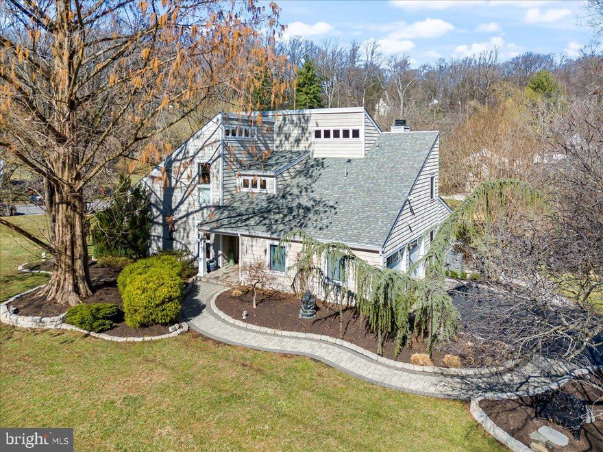 Move right into this meticulously renovated four-bedroom, two-and-a-half-bathroom showplace featuring expansive interiors and lush outdoor space in an ultra-rare Wayne location zoned for top-rated Tredyffrin/Easttown schools. Previously owned by a prominent Main Line architect and beautifully updated throughout, this turnkey 2,700-square-foot contemporary residence delivers dramatic open-plan living spaces filled with vaulted ceilings and skylights, walls of windows, fresh paint, gleaming hardwood floors and updated doors. A custom etched-glass entry door and marble entrance welcomes you inside the exceptional indoor-outdoor circular layout, perfect for comfortable relaxation and grand entertaining. The inviting living room flows to a spacious formal dining room and on to the newly renovated eat-in kitchen. Here, refinished soft-close maple cabinetry is trimmed with granite countertops, a prep sink and a deep undermount farm sink with a sprayer and instant hot water. Cooking and cleaning are effortless with all-new stainless steel appliances, including a five-burner gas cooktop with a professional hood, two wall ovens, a French Door refrigerator, a dishwasher and a microwave drawer. Enjoy casual meals under handsome pendant lighting at the wide center island/breakfast bar or the adjacent breakfast room. The adjacent family room is sure to become a favorite gathering spot with its marble gas fireplace and gorgeous outdoor views. A flexible layout, including a pantry, fitness room, powder room, mudroom entry and large storage closets add wonderful convenience to the well-planned main level.
From the breakfast room, the Andersen sliding glass doors invite you to enjoy a seamless indoor-outdoor lifestyle on the large paver terrace — the ideal destination for al fresco lounging and dining alongside a new, plumbed gas grill. The home's leafy 0.69-acre grounds are a secluded and serene nature lover's paradise featuring beautiful hardscaping, a new split-rail fence, newly added trees, specimen plantings and rolling lawns. Private quarters are tucked on the upper level for optimal peace and privacy. Head to the updated owner's suite to discover a king-size bedroom with vaulted ceilings and wide clerestory windows. The massive walk-in closet attends to wardrobe needs while the exquisite en suite marble bathroom impresses with an oversized shower for two, separate vanities, an illuminated mirror and radiant heat floors. Three spacious and bright secondary bedrooms with roomy, outfitted closets — including one with an attached home office — share a gut-renovated spa bathroom offering a deep soaking tub/shower with glass doors, a wide vanity, and designer-sourced porcelain tile with glass accents. An upstairs laundry closet with a new washer-dryer makes laundry day a breeze.  This home's extensive upgrades include Pella architectural casement windows, a new furnace and AC unit, a new sump pump and sewer line, replaced gutters with gutter guards, and new garage doors. A long driveway and attached two-car garage provide ample parking in this move-in ready Main Line residence. In this verdant, peaceful neighborhood, you're surrounded by abundant outdoor space, golf courses, award-winning T/E schools, and renowned colleges. Enjoy an array of fantastic shopping venues minutes from your door, including the King of Prussia Mall, Trader Joe's, Wegmans, Walmart, Target and IKEA. With numerous local highways and three train lines nearby, you'll enjoy easy access to Center City Philadelphia or wherever your travels take you.