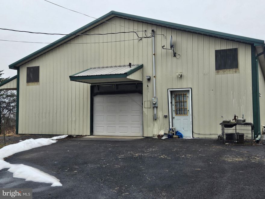 5.49 acres with a 3200 square foot, 40' x 30' metal building with garage doors front and back. Suitable for building and privacy. On site well and electric. Cabin was divided into 4 bedrooms. Possibilities are endless with this property.