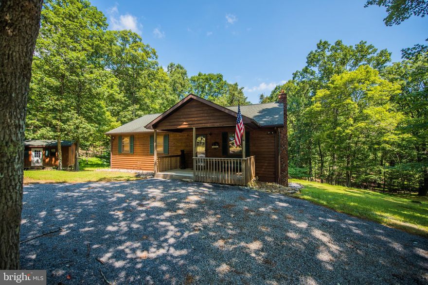 Located 14 miles west of Berkeley Springs in a locked gate community with  well maintained community park area on the Cacapon River with BBQ pits, picnic tables, and bath house. Whether using as a weekend retreat or a full time home, the community gated access offers added comfort and security. Situated on 5.49 wooded acres and just 1.2 M from the community river access.  Home features with open living room, kitchen & dining area with high ceilings, oak floors & wood stove for those cool evenings.  Front porch and screened deck offer a retreat during the warmer weather.  3 BR/ 1 BA on the main level. plus full unfinished basement with rough in for additional bathroom . Quiet, peaceful tranquility awaits.