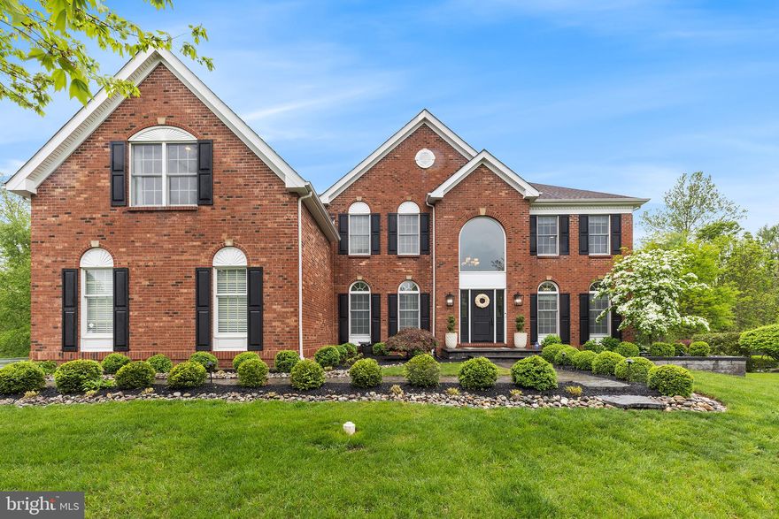 Welcome to this stunning brick-front Colonial nestled in sought-after Bridle Estates. Situated on a premium lot backing to serene woods, this exquisite 5 bedroom, 3.5 bath home offers refined luxury and exceptional attention to detail throughout. A timeless paver walkway leads to the new front door, flanked by upgraded exterior lighting. Step into the grand two-story foyer featuring a dramatic turned staircase and gleaming hardwood floors that continue throughout the main living areas. To the left, a stylish home office with French doors provides the perfect work-from-home retreat. To the right, a formal living room—complete with chandelier—offers flexible use as a dining room if desired. The heart of the home is the show-stopping gourmet kitchen, a true chef’s dream. Thoughtfully designed with Mouser inset custom cabinetry, quartz countertops, marble backsplash, and a farmhouse sink, this space is as functional as it is beautiful. The massive 16-foot center island includes two in-island refrigerator drawers.  High-end appliances include a Wolf range, Bosch dishwasher, wall oven and microwave, Sub-Zero refrigerator with pantry surround, and a sleek bar area with beverage fridge and icemaker. A wall of windows fills the space with natural light and overlooks the private, tree-lined backyard. The kitchen flows seamlessly into a spacious dining area and an inviting family room with a floor-to-ceiling stone gas fireplace, plantation shutters, and a convenient rear staircase. A sliding glass door leads to a composite deck, with stairs down to a custom paver patio—perfect for outdoor entertaining. The main level also features a gorgeous powder room, and a functional laundry room with new washer and dryer, utility sink, and access to the 3-car garage (partially converted for storage, but easily reversible). Upstairs, the primary suite boasts beautiful wood floors, dual walk-in cedar closets, and en suite bath with updated fixtures. Four additional bedrooms offer plush carpeting, ceiling fans, and share a nicely updated full hall bath. The stunning lower level provides additional living space, and is beautifully finished with luxury vinyl plank floors, custom built-ins, beverage fridge, recessed lighting, and a daylight push-out casement window that opens as a pass-through to the back patio—ideal for entertaining. A pocket door leads to a spa-inspired full bath with rain shower, and additional spaces include a built-in office with barn doors, a home gym, and a charming under-stair dog house. A full waterproofing system with French drain and dual sump pumps provides peace of mind. Additional highlights include 2 new HVAC systems, new water heater, Newer roof & siding (2012), New garage doors, Electric pet fence around entire perimeter of yard.  This home truly offers the best of elegance, functionality, and comfort in one of the area's most desirable neighborhoods.