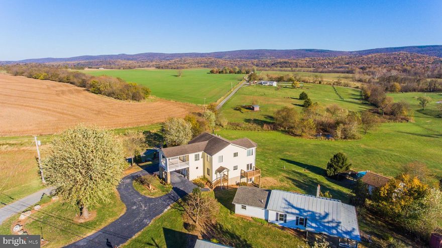 Oh the views!!!! This home was built to capture them all and the photos show it!. Custom built and one owner. This home sits on the high point of the property with almost 13 acres of property surrounding with additional buildings including a detached unfinished house with heat and water (would make a wonderful guest house or in-law quarters), pond and heated storage building with above ground pool. The land can be farmed, horses allowed, organic farming, gorgeous vistas. The home offers complete wood flooring, covered front porch and decks on two levels, bay and bow window area with panoramic window viewing, geothermal heat/cool. Freshly painted interior, professionally cleaned, power washed exterior, fresh gravel drive. Picture yourself living in this beautiful property with seasonal views to enjoy year round.