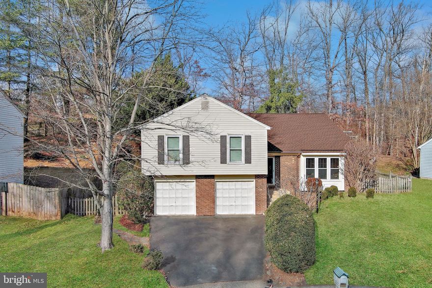 TRULY SPECIAL 4 BR, 3 BA Contemporary Split Level tucked into a quiet cul-de-sac in desirable Terra Grande community.   >> > DILIGENTLY MAINTAINED with  New Roof (Nov. 2025) + High Efficiency HVAC Heat Pump System (2023) + Preventive Outdoor Drainage System with Sump Pump (2020) + Crawlspace Sump Pump (2024)  >>> THOUGHTFULLY UPDATED:  Open Concept Floor Plan with Remodeled Kitchen, New High Efficiency Direct Vent Gas Fireplace, Dining/Sunroom Addition, New Paint, Refinished Hardwood Floors, New Carpet, Decorative Orleans-Style Wrought Iron Railings on Staircase & Balcony overlooking Living Room with dramatic 2-Story Vaulted Ceiling.  Upstairs, a Wide Open Common Area features a re-imagined Custom Kitchen with solid Maple Cabinets topped with Granite Counters, a 7-ft Breakfast Island with an inset sink and stylish pendant lights, a ducted range hood, new microwave (Dec. 2025) and range (Nov. 2025), a 2024 refrigerator, and a like-new dishwasher.  The focal point of the adjacent family room is the 2024 Natural Gas Fireplace with a Chic Custom-Designed Surround.  The dining/sunroom was added, complete with a Cathedral Ceiling, Skylights and Nature Views.  Exit to a private, wooded fenced-in backyard - a birder's paradise!  Admire seasonal blooms, delightful shrubs and ornamental trees displayed in terraced garden beds.  Host BBQs on your low maintenance composite deck.  A private hallway presents a huge primary suite with generous closet space.  The updated en suite BA has a large walk-in shower and a mirrored vanity nook for make up and hairstyling.  Down the hall, two sizable BRs share an updated Hall BA.  The fully finished ground floor offers a 4th BR (with window & closet) and a 3rd full BA.  If not needed as a BR, this large, versatile room is perfect for media/gaming, a gym, or home office.  The utilities & laundry are on this level, and a bonus room for storage, gym equipment or a home office as needed.  Exit to the spacious two-car garage.  Whether reporting to Fort Belvoir, the Pentagon, or somewhere in between, 95/395/495 and the Fairfax County Parkway will get you there!  With a Unique, Modern Floor Plan, Thoughtful Updates and a Peaceful Location within an Inviting Neighborhood, YOU WILL LOVE YOUR NEW HOME!
