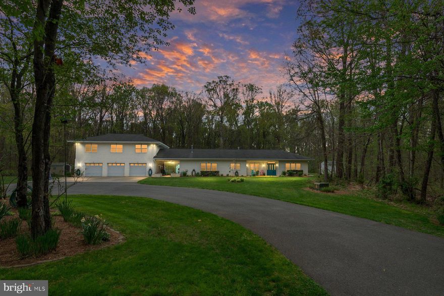 Tucked deep within 5 secluded wooded acres, this custom-built all-brick rancher offers a level of privacy, space, and versatility that is rarely found in Edgewater. Set well off the road and surrounded by mature trees in every direction, the property feels like a quiet retreat while still being conveniently located to everything the area has to offer. Designed for true one-level living, the main residence features four spacious bedrooms and 3.5 baths, with a thoughtfully designed layout that offers both functionality and  flow. The heart of the home is an oversized kitchen with a large center island, quartz countertops, gas cooking, double ovens, stainless steel appliances, and an expansive eat-in area with built-in cabinetry—ideal for everyday living and entertaining. Just off the welcoming foyer, a stunning mahogany library showcases floor-to-ceiling woodwork, custom built-ins, and a stone-surround gas fireplace, creating a warm and refined gathering space that is rarely seen. The home also offers a spacious formal dining room and an oversized family room that is filled with natural light.  The main living areas are complemented by expansive sliding glass doors that open directly to the outdoor living spaces, creating a seamless connection between the interior and the private courtyard beyond.  The primary suite is generously sized and includes a walk-in closet and a private bath with an oversized walk-in shower and neutral ceramic tile. Additional bedrooms are well-proportioned, including one with its own en-suite bath—perfect for guests or flexible living arrangements. Throughout the home, custom finished concrete floors add a unique, marbled aesthetic, blending durability with a distinctive design element that complements the natural surroundings. Outdoor living is equally impressive, with a private courtyard and an expansive stamped concrete patio—ideal for dining, entertaining, or simply enjoying the peaceful setting. The property is enhanced by extensive hardscaping, brick walkways, and multiple outbuildings, including a garden shed with electricity. The fully brick exterior extends to an oversized three-car garage, offering ample space for vehicles, hobbies, or storage. Above the garage, a beautifully finished two-bedroom, one-bath guest apartment with a full kitchen and living area provides exceptional flexibility—perfect for guests or multi-generational living.  With a circular driveway, abundant parking, and a setting that offers complete privacy, this property presents a rare opportunity to own significant acreage in Edgewater with a home designed for both comfort and long-term versatility.