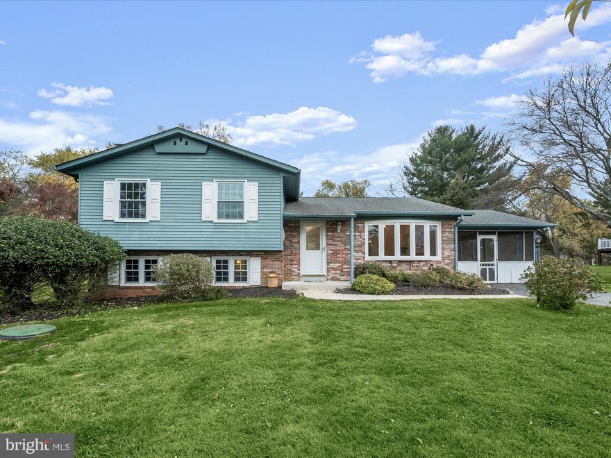 Welcome to this expansive 4-bedroom, 2.5-bath, 4-level split home, perfectly situated on nearly an acre of beautifully landscaped, level grounds. This residence boasts an inviting sun-drenched open floor plan showcasing a high vaulted ceiling, with freshly painted interiors and brand-new carpeting. The spacious living and dining areas  flow seamlessly, offering sliding door access to the serene backyard.  The eat-in kitchen highlights hardwood flooring and is a chef’s delight, featuring granite countertops, light wood cabinetry, a new dishwasher, and a breakfast nook. Upstairs, the primary suite offers a tranquil retreat with a large walk-in closet and an en suite bathroom. Two additional bedrooms and a hall bath complete this level.  On the first lower level, enjoy the warmth of the family room with its brick-accented wood-burning fireplace, alongside a versatile flex room and a convenient half bath. The second lower level expands your entertainment options with a recreation room, featuring a stylish dry bar highlighted by block glass tiles. Ample storage and walk-up access to the backyard add to the home's functionality.  Step outside to enjoy the expansive patio and the huge, screened porch, perfect for outdoor relaxation or hosting gatherings. Located just minutes from the Applied Physics Lab, Maple Lawn, major travel routes, and an array of dining options, this home combines comfort, style, and convenience. Fresh paint and carpet throughout ensure it’s move-in ready!