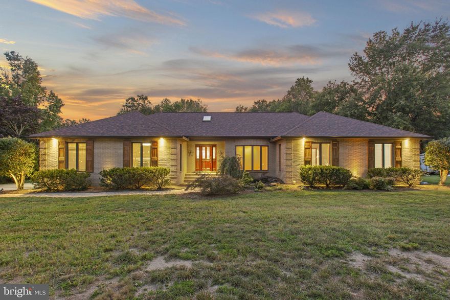 Welcome to 212 Morgans Ridge Ct, a one-level all-brick ranch with new hardwood and tile flooring throughout, a new roof, fresh paint, and a brand new deck to be installed. This home sits on 1.55 acres just outside the La Plata town limits; no HOA fees or town taxes! The impressive great room is the heart of this home, boasting a wood-beamed vaulted ceiling, a brick fireplace, and built-in shelves.  A spacious deck overlooking the large, fully-fenced backyard can be accessed from both the dining and great rooms. The current deck will be renovated by the sellers in the coming weeks. The home offers three bedrooms away from the main living area for added privacy. The primary suite includes a walk-in closet and an ensuite with a jetted tub, double sinks, and a walk-in shower. French doors in the primary suite lead to a second private deck with a screened gazebo. A bonus room off the foyer can be used as a formal living room, den, office, or fourth bedroom. Exterior highlights include refinished shutters and front door, a koi pond with a fountain, sprinkler system, and landscaped lighting. The garage and concrete driveway offer ample parking and a 50-amp RV outlet. The driveway extends into the backyard to a large shed/workshop, which is complete with electricity, exhaust fan, ceiling fan, and loft storage. There is an extra parking pad, perfect for even more recreational vehicles. Come see this lovely home today.