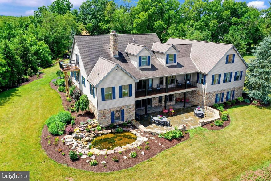 Welcome to Wildflower on Winding, a 43-acre farm with a stunning home, a sizable stocked pond, and frontage along the flowing Conewago Creek.   This property is meticulously maintained and set back a long sensored driveway with lush landscapes, a vegetable garden, ornamental fruit trees, rolling green lawns, and fields of soy, bean, or wheat crops.  There is a 45x85 bank barn and a 60x40 metal shop with three 14' overhead doors, including electric openers.   Plenty of room for your RV, tractors, or equipment.  This custom home is a true example of simplistic elegance.  Stunning Brazillian cherry floors.  Plenty of windows,  allowing the natural light to enter.   A foyer with a soaring ceiling and dramatic 12-light chandelier, complete with an electric hoist to raise and lower for convenience.  A chef's kitchen, designed to be the heart of this home, includes a fireplace featuring custom stonework from Grimm Brothers.   All appliances are high-end stainless steel, a five-burner professional gas range with a pot-filler, a Thermodor oven & warming drawer, custom cabinetry & granite surfaces.   This area also accesses the upper balcony.  Picture yourself enjoying your morning coffee with unobstructed panoramic views of the rural countryside.  The house offers over 6,800 SF finished living area, with three bedrooms on the main level including a primary bedroom suite with ensuite,  three additional bedrooms plus an office on the second level, and for those that host guests or have extended family, the lower level is completely finished with separate living quarters.  Including a second kitchen featuring a marble backsplash and a custom live-edge dining area, a stunning contemporary bedroom, a full bath, and a large recreation room with a wood-burning stone fireplace, all to be enjoyed with the comfort of radiant heated floors.  This level walks out to the extended hardscape courtyard.  Relax and enjoy the sights & sounds of the waterfall at the 20x16 Koi Pond, or enjoy a leisurely paddleboat ride on your private pond, stocked with plenty of bass, crappie & catfish.   The home is perfect for entertaining or everyday living.  There is always plenty to do here at Wildflower on Winding.   Farming, hunting, riding, kayaking, fishing, or enjoying the wildlife that makes frequent stops, such as whitetail deer, turkey,  fox, ducks & geese.  The property is also enrolled in the Clean  & Green program for tax-saving benefits.   One would be hard-pressed to find a property with such a serene setting, with an elegant dream home perched in the middle of fourth-generation farm fields.  Centrally located just minutes to Hanover & Gettysburg, 30 minutes to the Maryland state line, and one hour to Lancaster, PA or Baltimore, MD.    Shown by appointment only.
