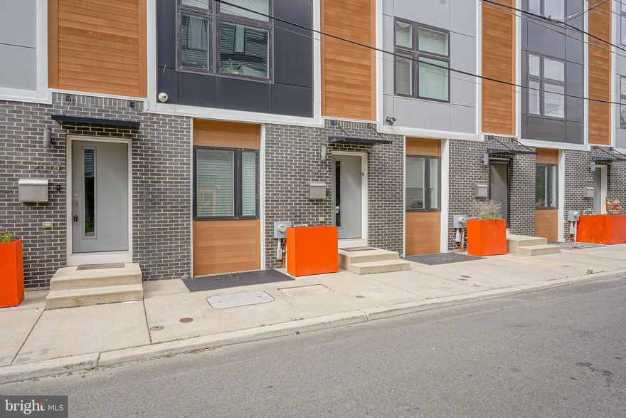 ** Ask for link to VIDEO TOUR ** Location. Lifestyle. Luxury. Perfectly positioned right by Fishtown, this stunning contemporary townhome offers the ultimate blend of urban sophistication and convenience. Nestled within a rare and exclusive, gated community called Blair Gardens. This exquisite residence offers multiple years of tax abatement, garage parking (EV charging available), two outdoor spaces, and access to a well designed common area. Experience unparalleled walkability to Fishtown’s vibrant nightlife, acclaimed restaurants, cozy cafés, lush parks, and eclectic boutiques. Commuting is effortless with quick access to I-95 North & South, New Jersey bridges, Philadelphia International Airport, and the Market–Frankford Blue Line connecting you to Old City, Center City, University City, and beyond. This home is equipped with hard wired CAT6 for internet, security system with cameras (interior and exterior), integrated home speaker system on multiple levels, newer roof with 30 year warranty, etc. Sunlight floods the interior through oversized windows, accentuating the 9-foot ceilings, rich hardwood flooring, and custom designer finishes throughout. The entry level features a versatile bedroom or home office, a stylish full bath, and convenient garage access. The oversized garage offers sizable storage space. A finished lower level features home theater, with incredible surround sound. This additional space ideal for a media room, gym, or play area. Upstairs, the open-concept main living level is an entertainer’s dream. The chef’s kitchen is appointed with an island, subway tile backsplash, generous storage space and premium appliances. The sliding glass doors invite desirable fresh air into your living space. Step onto your private deck for morning coffee, weekend grilling, or intimate outdoor dining. The living room centers around a striking stone-accented gas fireplace, creating the perfect balance of warmth and style. Retreat to your primary suite, a serene sanctuary boasting oversized windows, custom built-ins for storage and a beautiful en-suite bath. A convenient hallway laundry area and a guest suite with a private bath complete the upper level. Entertain effortlessly on your rooftop deck, where city skyline views set the backdrop for evening cocktails or weekend gatherings. The spacious layout accommodates both lounging and dining with ease. Residents also enjoy access to the landscaped outdoor common area, ideal for casual get-togethers and friendly neighborhood connections. Do not miss out on this rare opportunity.
