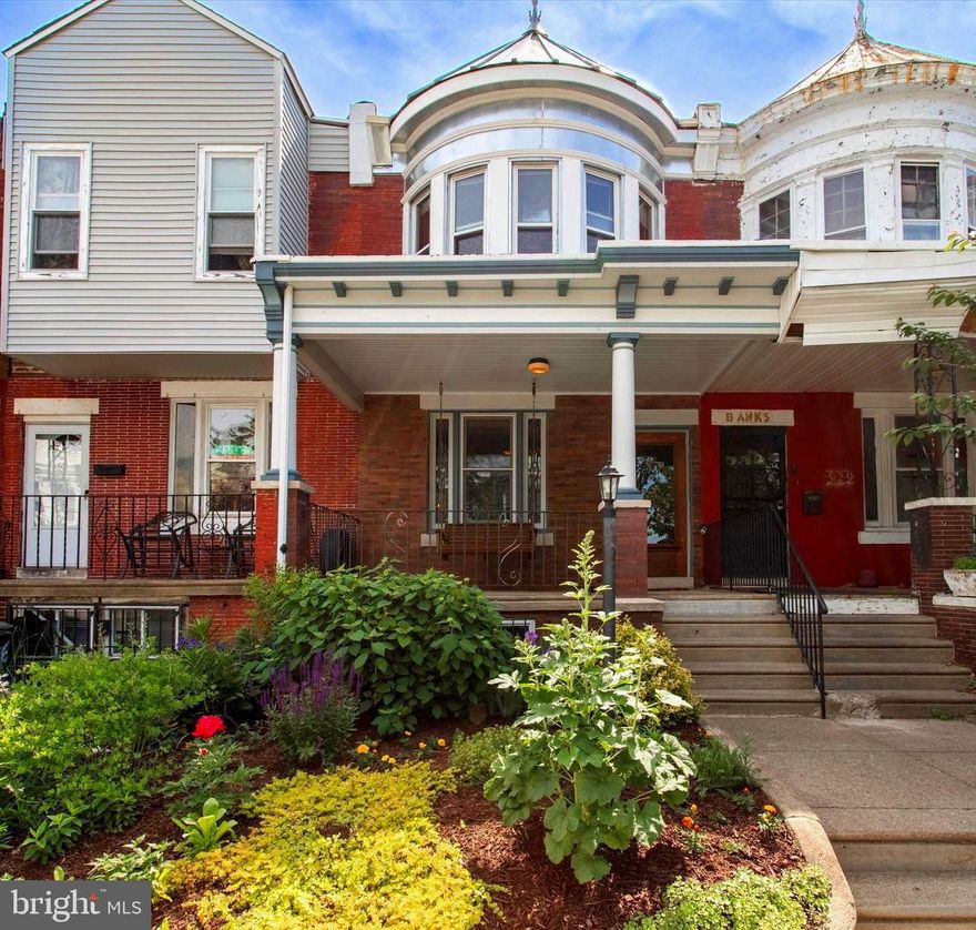 There’s classic West Philly charm, then there’s extra-special West Philly charm–and that’s what one lucky buyer will get here. On top of the leaded glass and almost all the original unpainted doors in place, there are design-forward custom upgrades inside and out. The University City Historical Society’s award-winning restored porchfront facade sits behind a garden with mature landscaping that provides year-round color and spring-to-fall blooms. The original millwork in incredible condition starts at the vestibule entry, where there’s a glass-paneled entry door and leaded glass interior door, wainscoting and original tile floor. The living room features a leaded glass window, original oak parquet flooring with walnut inlay, a turned staircase with curved banister, and an exquisite decorative fireplace and mantel. An extra-wide doorway is the airy segue to the large dining room, which has an oversized window, sweet under-stair closet and swinging door with leaded glass to the eat-in kitchen. While all the right things were left untouched in the main living space, all the right things have been updated here: recessed lighting, white flat-front cabinets and appliances set against beautiful handmade porcelain tile backsplash, and quartz countertops. The great layout with original pine floors includes a salvaged wood coffee station, a clever hidden pantry cabinet, and a U-shaped work area with salvaged wood breakfast bar that overlooks the dining area with a pair of windows and vintage pendant. Tucked in the rear is a super-stylish powder room with oversize black hex tile floor, sleek black wall-hung radiator with exposed copper piping, custom wood vanity with concrete top, casement window, and a custom triangular window in a corner. This window makes just as much of a design statement from the rear deck–which overlooks the good-sized yard with privacy fence–where it is set into a diagonal wood slatted wall. The second floor offers the same pristine original charm, including oak floors with walnut inlay, met with just-right updates where it matters–the hall bath has white hex tile floors and subway tile surround and a new linen closet. Either the front or back bedroom could be the primary. The front is an enormous space with a five-window bay, while the rear has original mirrored closets flanking a window overlooking the yard and connects to a middle bedroom that is currently used as a sun-filled dressing room. The other sunny middle bedroom is large enough for a full bed. This lovely, garden-lined Cobbs Creek block is convenient to Christy Rec Center, which has a pool and is currently undergoing major renovations and upgrades, Cobbs Creek Park for more greenspace, and Baltimore Ave shopping, dining and the trolley into Center City.