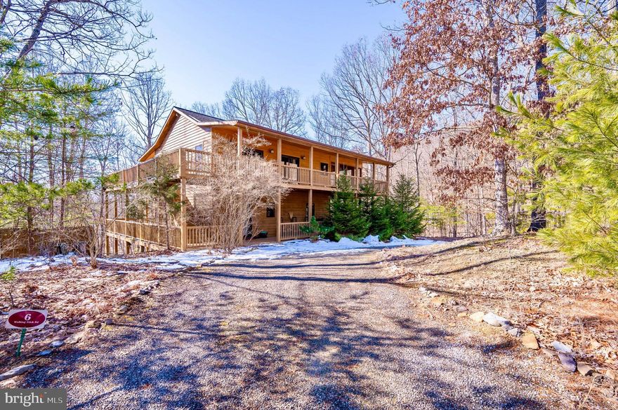 This immaculate cabin is being offered fully furnished and with a well-equipped kitchen. Tucked away on a corner lot in the quiet Summit at Lost River community (thesummitatlostriver.com), you will be awed by how well this cabin has been maintained by the original owner. Inside you will find beautiful pine and tile floors throughout. There are two large bedrooms, each offering a full ensuite bath and plenty of closet space for storage. On the second floor you will find a great room with a cozy hand-crafted stone fireplace and a convenient half-bath. The large open floor plan is perfect for entertaining friends and family. The two large porches offer outdoor living in spacious screened-in areas, with the two wraparound decks affording additional space to relax in the fresh mountain air.  Surrounded by the beautiful West Virginia forest and with views across the Lost River Valley, you will feel at peace. High-speed fiber optic internet service provides the convenience of working remotely if you so desire. Make an appointment to see this hidden gem today!