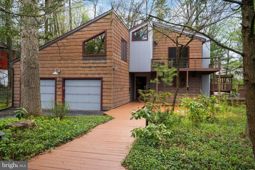 This magnificent College Heights Contemporary marries elevated design and prime location. Whether you are seeking a soothing respite or the ideal home to entertain in all seasons, this architectural gem has it all. The first floor features a circular floor plan and wrap-around deck for easy living. You will find a stylish kitchen with plentiful cabinetry, a dining area with a built-in wet bar, built-in book cases, and an inviting living room. Like the rest of the house, the expansive sunroom, which features in-floor radiant heat, lets the outside in through wrap-around sliding-glass doors and skylights. Completing the main level is a foyer, generously sized powder room, expansive laundry/mudroom, and two-bay garage. Upstairs, the luxurious primary suite has an ample walk-in closet, built-in storage, and a bathroom featuring a heated floor, tiled shower, double-sink, and separate WC. An office of your dreams is nestled in the treetops and drenched in natural light. Upstairs also sports two additional bedrooms, one with cathedral ceilings and the other with its own spacious balcony. Completing the second floor is another full bath with a separate water closet and walk-in shower suite that also includes a huge soaking tub. Outside living areas surround the entire house. The calming wooded-views will make you wonder if you really are just a short walk from campus. Across the street, a path leads directly to Sunset Park with its plentiful gathering spaces and hiking paths and the Hartley Wood wildflower trails. Campus, the Stadium, downtown, North Atherton shopping, and bike trails are all within easy reach.