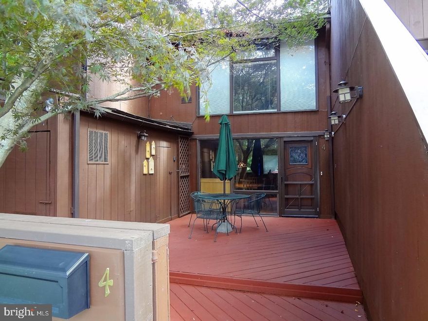 A charming garden area and a gate into your own large lighted patio with towering shade tree are what greet you. Then you see the entry door. And what a door it is! Custom carved with an inset of exquisite stained glass made by the renowned Bucks County artist Val Sigstedt/Chris Snyder, it is a work of art that sets the tone for what awaits inside. Filled with unique custom features, this is not your ordinary townhouse. First thing you see is a spacious entry area with tile top island/table that is open to step-down kitchen with maple cabinetry. Glass pendant lights w/decorative covers, ceiling pot rack, track & recessed lights, GE electric convection range with 5 burners, warming drawer & SS hood, Maytag side by side refrigerator and a Bosch dishwasher set into the island on the kitchen side. Beautiful backsplash of Mexican decorative tiles add an immediate wow factor.  Mexican tile is the flooring throughout the house except for wood floor in the hall at the top of the easy to navigate spiral staircase with wood treads. The focal point of the great room is a dramatic floor-to-ceiling stucco fireplace with intricate hand carved wood surround and mantel set into a wall of glass that overlooks the brick rear patio with access from another custom stained glass door by the same artist. Even the powder room is spectacular with a custom designed door and painted decorative sink set into a tile top vanity that is part of a full height wood cabinet surround. Be sure to note the charming door & cabinet hardware and the stackable washer/dryer. Upstairs does not disappoint. Master bedroom has shed ceiling with beams, double closets, ceiling fan w/lights, decorative millwork. Second bedroom has walk-in closet, beamed shed ceiling with knee wall that shows the wall of glass in the vaulted area below and view outside. Full bathroom features a spacious custom tiled shower with decorative accents, shelves and niche, handheld faucet plus showerhead. Other features include a storage shed built into the front patio area plus enclosure for A/C unit. A supplemental A/C unit is in master bedroom and can run on its own. Village II residents enjoy swimming pools, tennis courts and other recreational amenities. One-year Home Warranty included. With close proximity to New Hope and the best dining, shopping & cultural amenities that Bucks County offers, this special home will delight you every time you enter. Welcome home!