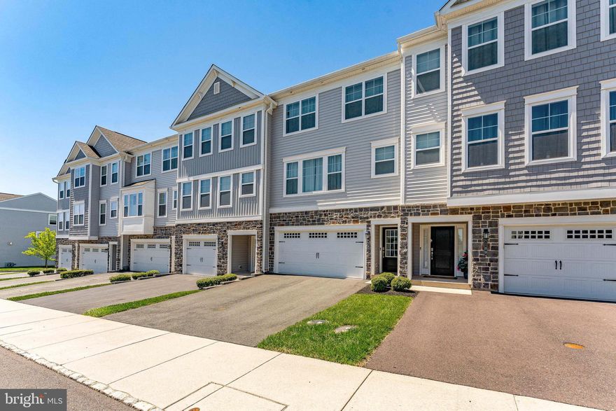 Welcome to 187 Larrabee Way, a 3-bedroom, 2.5-bath townhouse in the Everleigh community of Royersford. As you approach, a two-car garage and driveway provide ample parking and convenience. Inside, the foyer features engineered hardwood flooring and leads to a lower-level family room with direct access to a patio, offering additional living and entertaining space. A set of steps brings you to the main living level. The kitchen is well-appointed with quartz countertops, a center island with seating and pendant lighting, and stainless steel appliances, as well as a casual seating area. The space flows into the living room, which includes a dry bar with a wine fridge. The dining room connects to the kitchen and features a vaulted ceiling, ceiling fan, built-in cabinetry, and a sliding door to the deck, creating an easy transition to outdoor living. A powder room completes this level. Upstairs, the primary bedroom offers carpet flooring, a vaulted ceiling, and a walk-in closet. The en-suite bathroom includes tile flooring, a double sink vanity, and a step-in shower. Two additional bedrooms provide flexible space for family, guests, or a home office. A full hall bathroom with a tub and shower combination and a conveniently located laundry room complete this level. Conveniently located near local shopping, grocery stores, restaurants, Landis Creek Golf Club, and Turtle Creek Golf Course, this home offers both comfort and accessibility. Don’t miss the opportunity to make this your new home.