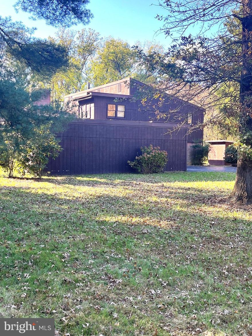 Excellent opportunity to purchase from original owner.  Houses on Crab Orchard seldom come  up for sale.  The price reflects the Sellers knowledge that Buyers will  likely want to renovate or remodel this home that is still in its original state.  It is a spacious Tri-Level house with a very large living room that has the dining room at one end.  The center of the wall features a rarely used wood burning fireplace.  The fireplace is flanked by sliding doors to the rear yard.  The vaulted ceiling really lends itself to an open feeling in this large hardwood floored area.  The two car garage enters into an enclosed storage area and then leads to sliders to the eat in kitchen.  The kitchen was the hub of the home for the original owners and they had a large table and entertainment center during the 50+ years they lived there.  You will feel a bit like you are stepping back in time when you enter the foyer with it's foil style wall paper that is reminiscent of the early 70's.  From the foyer there are beautiful wood stairs with iron railing leading up to the four bedrooms.  The primary BR  features a walk in closet, a full tub & shower bath plus a second sink between the closet and bathroom.  The vanities, sinks, etc. are all original, allowing you to make any and all changes you wish for.  In the hall there is a second full bath that services the other three bedrooms.  You will notice that there are sliders to the rear deck from the back bedrooms.  The sliders are currently screwed shut and will need  repair or replacement due to being fogged.  The deck area overlooks the beautiful back and side yard.  There is a tennis ball ct. that needs to be resurfaced or perhaps, you might choose to convert to  the growing game of pickleball.  From the foyer go down another half flight of stairs to the family room with a bar, sliders to side yard, bathroom with shower,  a 5th bedroom (or office).  Flip on the light switches behind the bar and enter the former theatre room.  You could choose to open it back up to enlarge the family room, or re-create your own new theatre.  From that room there is a door that covers the slider to the back yard.  
With this fabulously convenient location, gorgeous yard and setting, the possibilities are endless for the homebuyer or investor.   The  homeowners do not know if the Voluntary HOA is still in effect, they had paid $20 per year for the first half of their lives there and the community had a Halloween Party for the children.  Please check with Baltimore County for any questions you may have in regards to any potential Covenants & Restrictions.  The property appears to have two wells.  When the owners 1st bought the house there was not enough water.  They had a new well drilled, which they say performed fine,  and it does not appear that the original was abandoned.  They remember being told by the well driller they were allowed to keep it for gardening, car washing etc.  It would be the responsibility of potential buyers to verify this is accurate with Baltimore County.