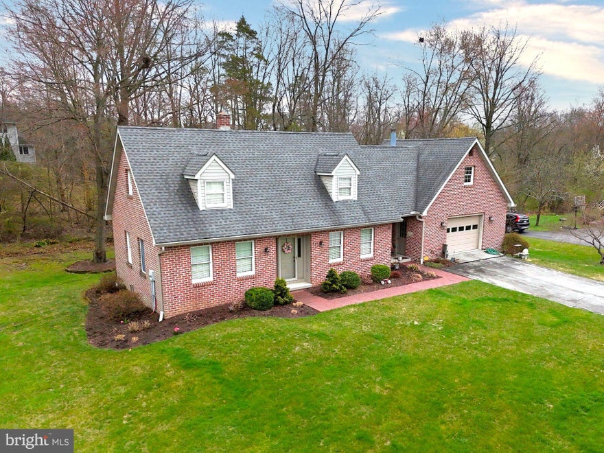 Nestled in an attractive neighborhood just outside the town of Gettysburg is this lovely, 3 bedroom, 2 bathroom, Cape Cod style home on almost ½ acre.  They don’t build them like this anymore with brick all around, solid construction, custom woodwork, and lots more.  This one-owner home features first floor living with a bedroom and full bathroom on the main level to include an accessible, tiled, stand-up shower, heated tile floors, and laundry facilities.  A cozy living room with vaulted ceilings and fireplace, currently with an electric insert, is a great space to enjoy.  Upstairs are two bedrooms, walk-in closets, and a full bathroom.  Enjoy the outdoors while relaxing on the covered front porch alcove, or on the back deck overlooking a rear wooded property boundary.  An oversized garage with a loft above, full unfinished basement, 3-zone hot water heat/2-zone central ac, and public sewer, make this home a great find.