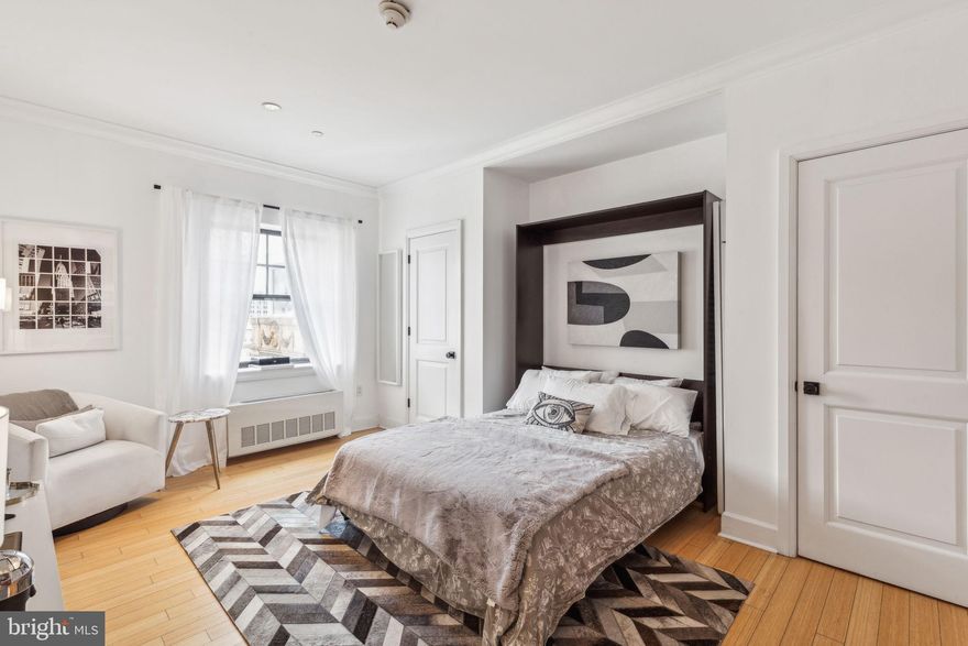 Beautifully appointed studio at The Warwick Condominiums atop The Warwick Hotel! Enter into a generously sized living/dining room with a large window showcasing Center City views, alcove perfect for a bed, and excellent closet space. The open kitchen boasts a granite countertop, wood cabinetry, and stainless steel appliances. The marble-appointed bathroom has a single wood vanity, glass enclosed walk-in shower, and stacked washer/dryer. There are hardwood floors and baseboard moldings throughout.  Residents of The Warwick enjoy the same amenities as hotel guests including 24-hour doorman service, a state-of-the-art fitness room, room service, maid service, valet parking, car service, and the use of three restaurants on the ground floor for additional fees. The building sits one block away from Rittenhouse Square.