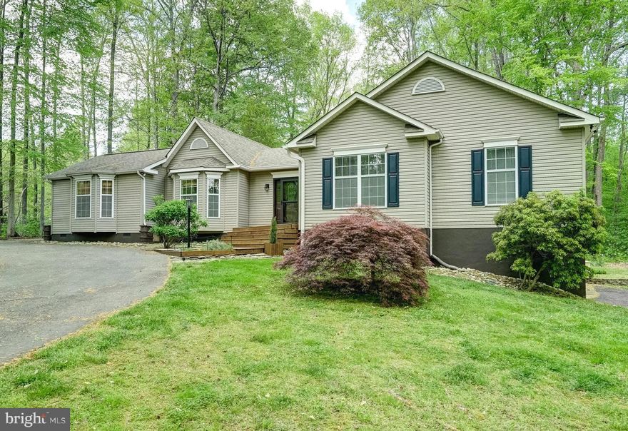 Nestled into a picturesque partly-wooded two-acre lot in the sought-after Oakleigh II community, a gated subdivision on the private side of Lake Anna, this expansive water-access retreat offers nearly 4,000 square feet of living space and an assigned boat slip (A10), just steps away—creating the perfect, laid-back lake lifestyle. With high-speed fiber internet from Firefly, this opportunity is equally suited for full-time living or weekend escapes from reality.  

Inside, the wide-open living room is anchored by vaulted ceilings and a seamless layout, all enhanced by a blend of hardwood flooring and brand-new luxury plank recently installed by the sellers throughout the home.  The thoughtfully-designed kitchen offers generous pantry storage, stainless appliances, and connects easily to the main living spaces, ideal for gathering and entertaining. The large main-level primary suite features an upgraded en suite bathroom with double vanity, soaking tub, and large tiled walk-in shower with niche, as well as a spacious walk-in closet.   Two guest bedrooms and a full bath on the main level provide comfortable space for family and visitors, while the finished basement adds another guest bedroom suite with full bathroom, additional recreation/living space, and a full-sized pool table that conveys for added enjoyment.  

Refined outdoor living takes center stage here with a freshly painted, oversized back deck, complete with a fun tiki bar stubbed for your propane gas BBQ—perfect for hosting on warm Saturday afternoons—alongside a massive screened porch (16x16) overlooking the peaceful backyard.  An enormous detached carport (30x30), attached garage, whole house generator, and large storage shed compliment with functionality, while the home’s close proximity to the community water access area ensures you’re never far from your own assigned boat slip (A10) and, most importantly, time on the lake.  

Recent upgrades include new roof in 2020, new HVAC in 2020, new hot water heater in 2019, new water pump bladder (2020), whole house water filter (2026).  Location is perfect: only minutes away from groceries, local restaurants, The Lake Anna Taphouse, Coffee & Creamery, ABC, a vet clinic, nail salon, and more.  Less than an hour to nearby Richmond, Charlottesville, and Fredericksburg, and just 82 miles from our nation's capital, Washington DC.