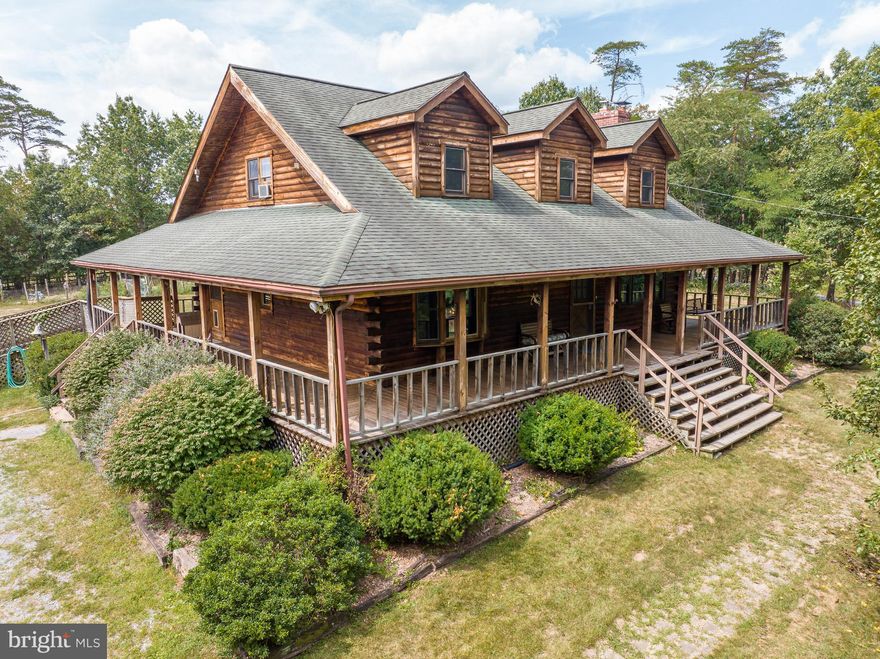 NO HOA. 10.82 Acres peaceful wooded lot with flat grassy area, fenced garden, green house and shed.  There is also a wet weather stream on the property. Beautiful Log Cape Cod Style home the porch wraps round the entire home. 3 bedrooms 2.5 bathrooms.  Owner's suite located on the main level.  Large eat in kitchen with new Dishwasher and stove. Under sink reverse osmosis system and water cooler bubbler convey.  The living room has a beautiful brick fireplace with woodstove insert. The mudroom/pantry has ample space to accommodate your needs. Upstairs two very large bedrooms with closets and storage. Large full bathroom upstairs as well. The unfinished basement has an exit to the backyard. Plenty of room for storage or blank canvas for new owner to finish if desired. The home has been well cared for and maintained just waiting for new owners to put their personal touches in. The owners have loved this home since 1994 and are retiring out of the area. Create your memories here. Seller has recently made some repairs to the property. Ask for more information.