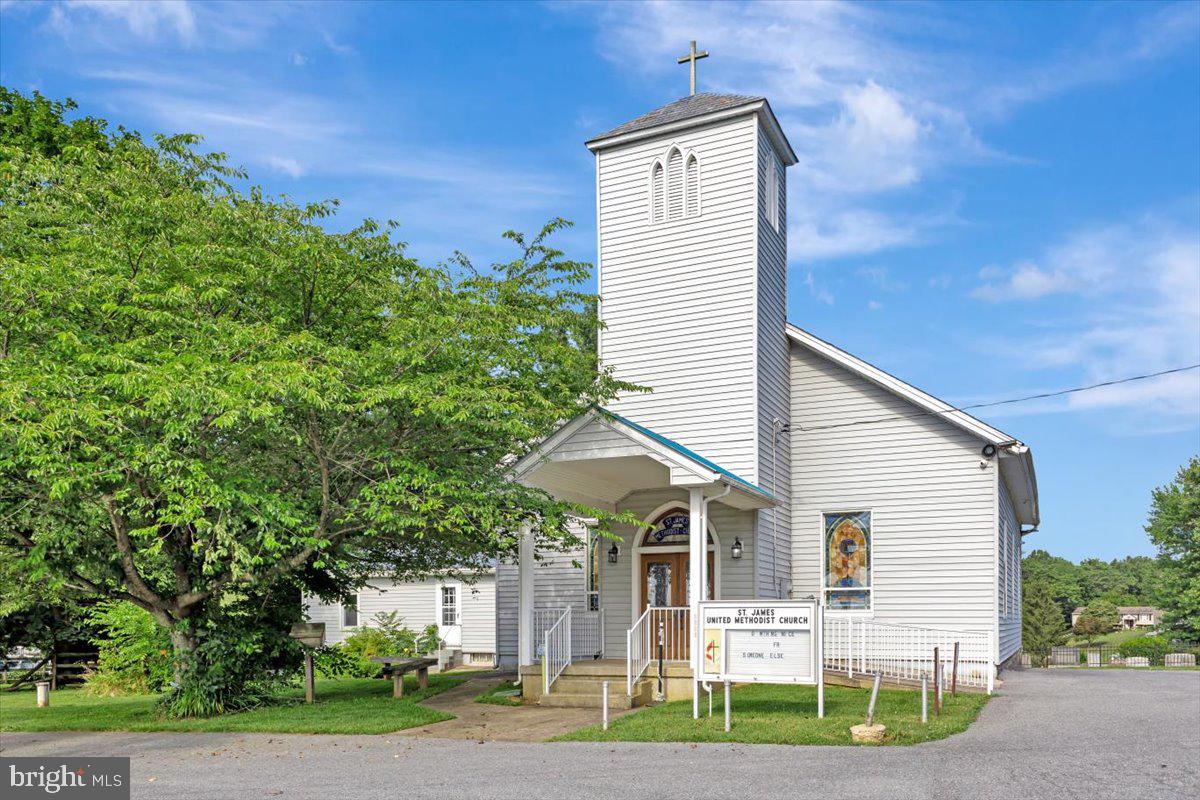 Discover the charm and opportunity of this beautiful historic church, originally built in 1878 and offering over 5,100 square feet of interior space. Set on a peaceful 0.7-acre lot surrounded by picturesque farmland, the property combines pastoral views with a convenient, expansive parking area.
A welcoming front ramp provides easy access into the building, where visitors are greeted by a dedicated entry area that opens into a spacious sanctuary adorned with stunning stained glass windows, filling the space with warmth and natural light. The building includes six large, windowed rooms that are ideal for gatherings, classrooms, or office use—each offering natural light and flexibility for a variety of needs.
The lower level features a generous 38' x 24' dining area alongside an impressive commercial-style kitchen equipped with a ten-burner gas stove, oversized sink, two refrigerators, and abundant cabinet and counter space—ideal for hosting community meals or events. This level also includes windows and a ground-level entrance, allowing for easy loading and unloading of supplies. An attached storage room in the rear of the building provides additional space for equipment or seasonal items.
Thoughtfully updated, the property includes one main-level bathroom and two on the lower level, as well as a stair-accessible chairlift that conveys with the sale. A new well, recently inspected septic system, dual oil furnaces, and central air conditioning on both levels ensure comfort and functionality year-round. A water treatment system is also in place for added peace of mind.
With agricultural zoning and a long history of use as a church, this property offers potential for continued religious use or a variety of other permitted purposes. It’s a rare opportunity to own a timeless structure with character, functionality, and serene surroundings.
Listing broker does not guaranty permissible uses, it is sole responsibility of buyer and buyer's agent to ensure buyer's intended use complies with zoning and land use through Carroll County and/or applicable government agency controlling parcel.