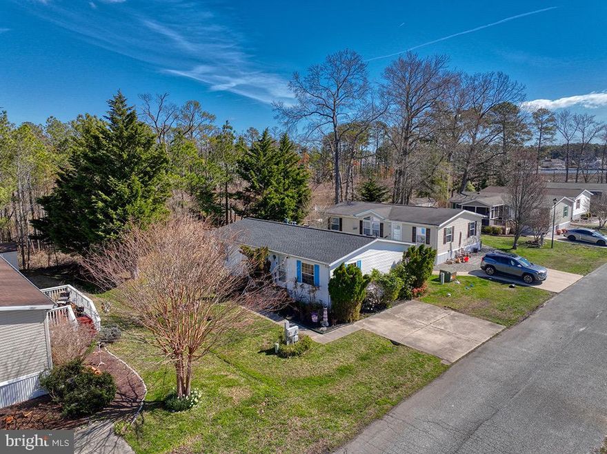 Welcome to 35959 Jake Drive where LOW lot rent, UPGRADED Roof, HVAC and Hot Water Heater plus total privacy abound! This combination is very RARE at this price in a community just 6.5 miles to the ocean. Make the inside your own by adding your decor flair! This 3-bedroom, 2-bathroom home offers convenience, privacy, and a truly quintessential "salt life" where boating, swimming, fishing, crabbing, and waterfront living are just down the street. Step inside to find an open-concept living space that flows seamlessly from the great room into the kitchen. The great room and the kitchen with a breakfast bar and dining space offer the best layout for convenience, entertaining and a bright feel with a skylight.
With a split floor plan, this home offers privacy and comfort for everyone. The light-filled primary suite and ensuite offer a space that you can truly find comfort and relaxation in. Likewise, the additional bedrooms and bathroom offer comfort and privacy for family or guests.
The laundry room leads to an extremely private backyard and both are accessible from the kitchen, adding to the home’s functionality. In the backyard, you can find a deck ideal for dining al fresco, mature trees that provide privacy, and a spacious yard with room for a garden plus a wonderful shed.
Some important systems within the home, such as the HVAC, hot water heater, and roof, have been upgraded within the last five years.
Residents of the Rehoboth Bay MHP Community have access to a variety of amenities, such as boat slips for rent, a boat ramp, a boat storage area, a bayfront pool, a crabbing/fishing pier, a private beach, tennis/pickleball courts, and much more. Situated just a few miles from downtown Rehoboth Beach and the Rehoboth Beach Boardwalk, this home allows for easy access to local shopping, dining, and activities. Whether you're looking for a full-time residence, a weekend retreat, or an investment opportunity, this home may be the one for you.