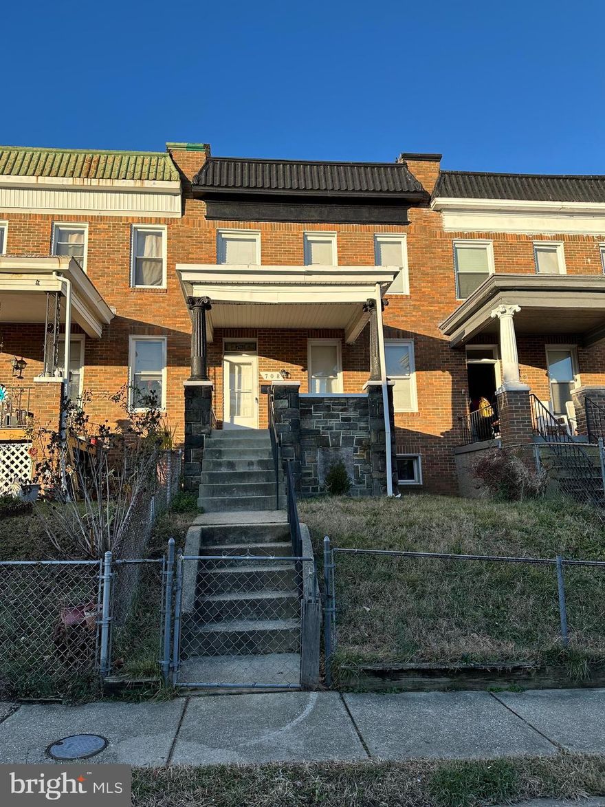 Decorative brick townhouse consisting of 3 floors, 4 bedrooms, 1.5 bath.  Entering from the front you pass through a gated grassy front yard, leading up to a large raised, covered porch designed with form stone which sits elevated over the street. The front door has a stained glass transom leading into a large foyer, ideal for decorations or mudroom.  Continuing straight through the foyer you enter an updated kitchen with quartz counter tops and stainless steel appliances. To the right of the foyer is a large living room with fireplace that leads into another large dining area.  The upstairs consists of a full bathroom and 4 generously sized bedrooms with ceiling fans.  The majority of the basement in finished with ample light and ceiling height, a 1/2 bath,  and a utility room with washer, dryer, and exit to rear yard. The back door exits the kitchen to a small deck and tree filled rear yard. The entire home has been recently updated and well cared for.