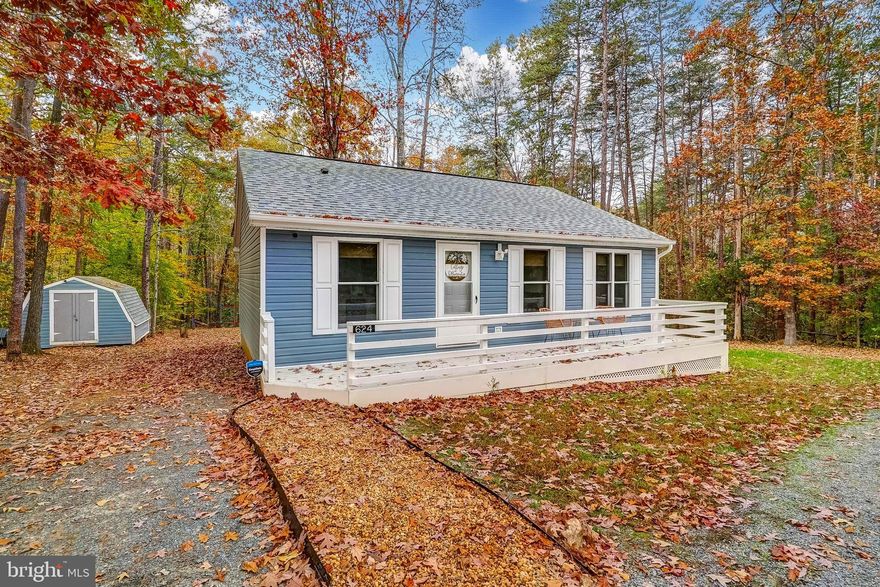 Imagine living in the most charming lake cottage you've ever seen - this home will steal your heart!  Completely renovated, redecorated, refurnished, and restyled, Joanna Gaines ain't got nothing on this thoughtfully-designed lake house on the public side of Lake Anna.  ALL FURNITURE CONVEYS!  Perfectly situated on a private lot within the coveted (and gated) Bluewater subdivision, this adorable home comes with your very own boat slip.  Inside, the appealing layout of the 3 bedroom, 2 bath floor plan truly maximizes your open interior space, leaving you relaxed and comfortable.  The kitchen truly glows, showcasing immaculate white quartz countertops, new stainless appliances, beaming gold fixtures, white kitchen cabinets, floating wood shelves, warm backsplash, and ample recessed lighting.  Connected to the spacious living room, this makes for a large open space, with a dining area, living room, beautiful LVP flooring, crown molding, and recessed lighting.   The primary bedroom features LVP, crown molding, closet, dedicated mini-split for independent temperature control, and it's own bathroom, with a gorgeous white vanity and gold hardware.  Your guests will enjoy two additional bedrooms with LVP, crown molding, closets, and dedicated mini-splits for private temperature control.  There is also a full bathroom near the guest bedrooms, with quartz countertop, white vanity and gold hardware.  Catch-up on laundry using the convenient hall laundry space.  Outside, unwind on the large deck, or unwind around the beautiful fire pit, with its very own pea gravel path that meanders back to the house.   Store belongings or yard equipment in the large matching shed, and cut loose on the playground out back.  This deal offers a rare opportunity because you'll also get the new furniture, furnishings, and decor - true turn-key purchase - with high speed FIBER internet.  This sought-after subdivision also offers a large event gazebo, boat ramp, sandy beaches, and more.  INVESTORS: this property has an established rental history that shows over $17,000 in rental income in just 6 months.   Lake Anna was recently ranked the top spot in the nation to own a short term rental!  Detailed rental history and improvements in the documents section.