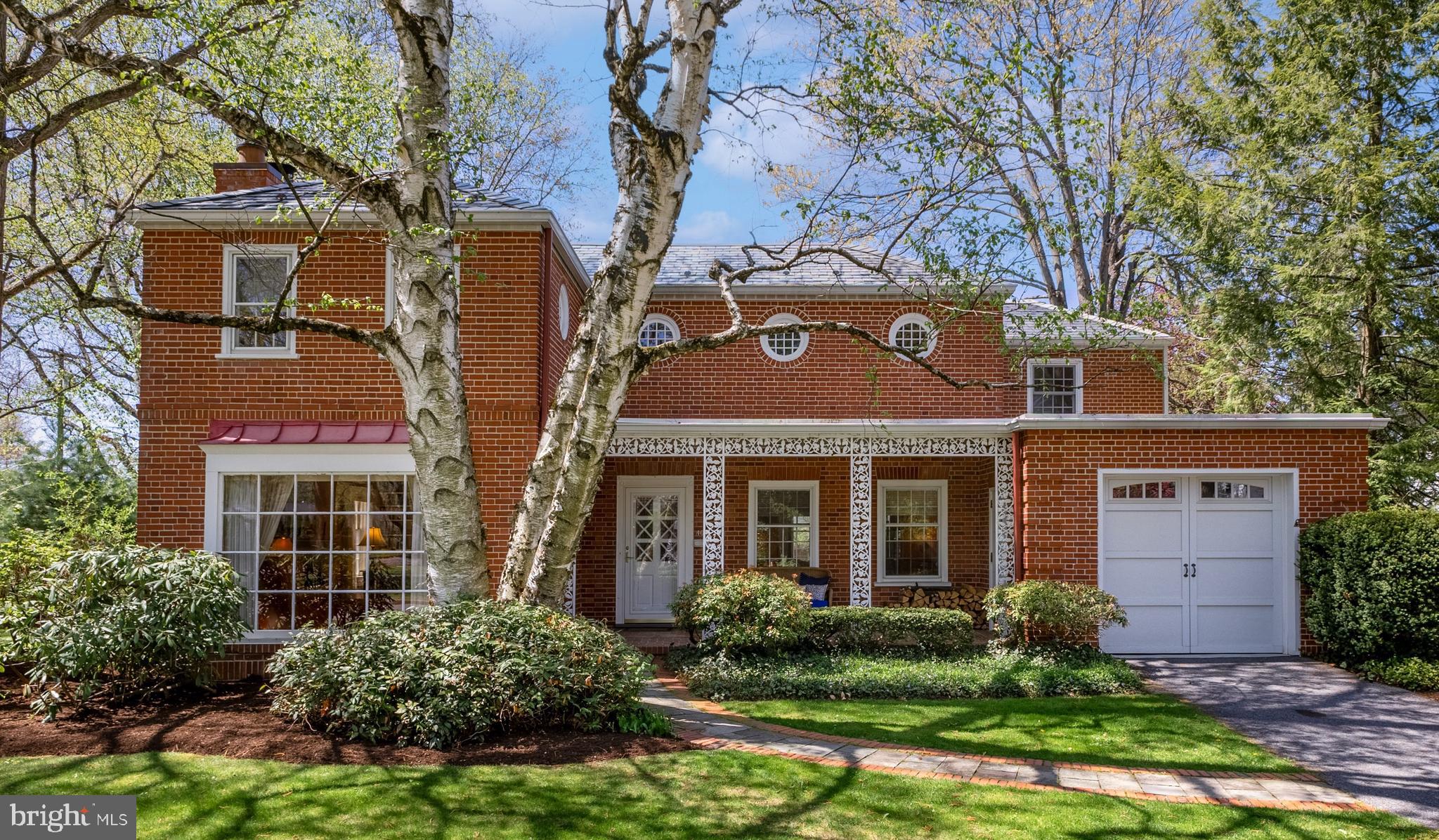 Enchanting and unforgettable! Fall in love with this masterfully designed College Heights Historic residence, crafted by architect Walter Eschenbach in 1939. Perfectly positioned on a corner lot surrounded by majestic trees and lush landscaping, this brick two-story home serves as your private sanctuary. Upon entering you are welcomed by a beautiful crafted kitchen featuring a stunning 14-foot granite island, stainless steel appliances and rich walnut hardwood flooring. The living room, complete with a cozy wood-burning fireplace and a wall of windows, exudes a warm and inviting atmosphere while seamlessly flowing into the formal dining room. Just off the kitchen, the sunroom provides an additional retreat offering access to a serene private patio. A mudroom and half bath complete the main level. The upper level includes a primary en suite with an updated bath and walk-in closet, plus two additional en suite bedrooms. The finished lower level offers a spacious family room with built-in shelving and distinctive window wells, along with a half bath and laundry room. The home also features a one-car attached garage and an additional two-car detached garage, perfect for extra storage, bikes, and more. Situated just blocks from the vibrant campus and downtown venues, this home combines historic charm with modern updates.