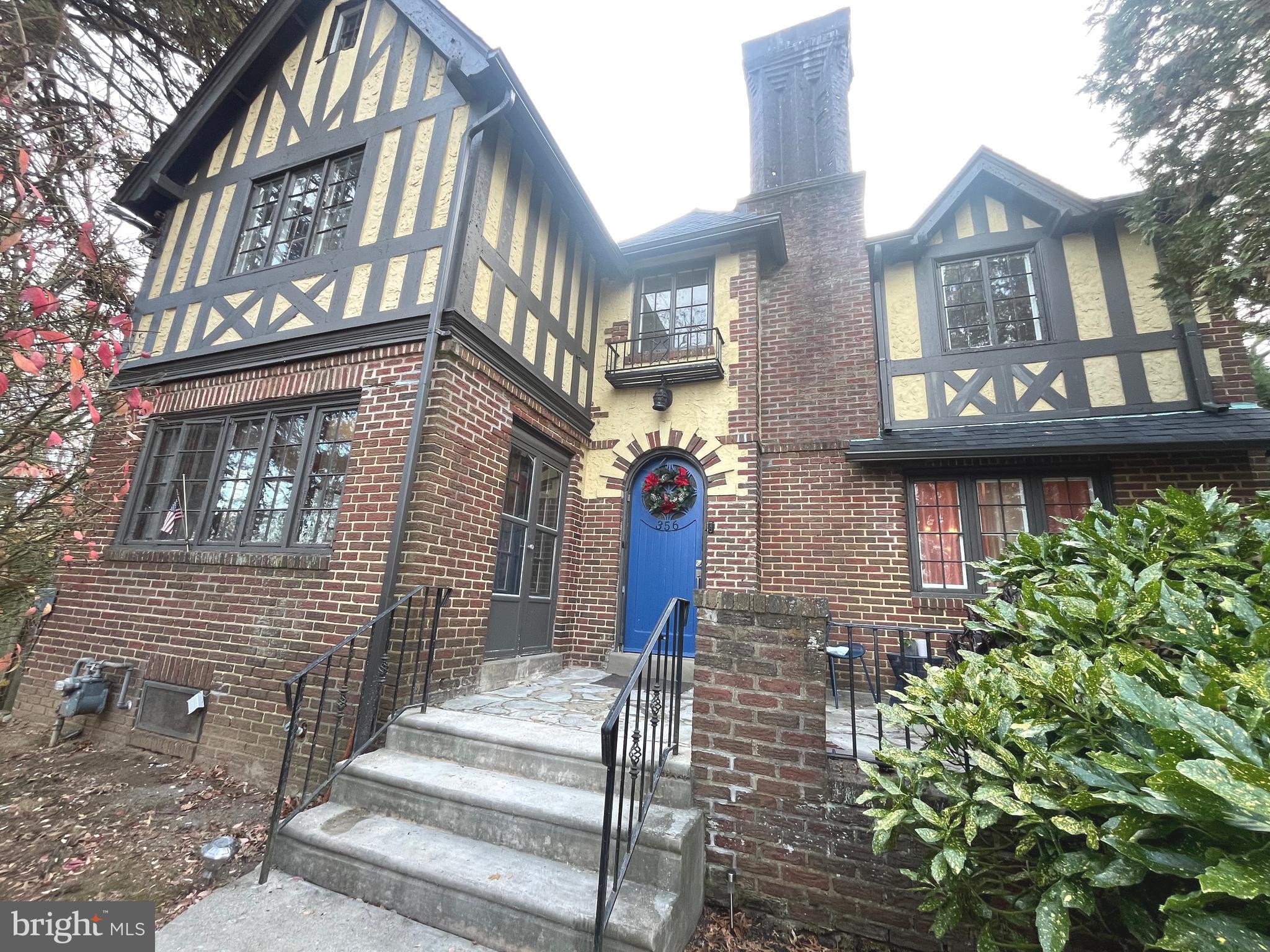 Welcome to this Tudor revival sitting graciously high on a hill in Drexel Hill! This unique property was built by a local architect in 1925 and he used it as his own personal residence. Just at first glance, you can appreciate the nostalgia of the plastered walls, red oak floors, metal windows and an 8' arched entry door. On the exterior, you can find beautiful English brick and a blue stone front patio with hints of wrought iron railings. Walk into the cozy foyer and notice a slight change in the floor plan, where the dining room and kitchen have been opened allowing for a more fluid path back and forth to the living room. The kitchen was updated about 8 years ago with 42" wall cabinets, stainless steel appliances and a large peninsula to work and prep food. Off the kitchen is an open pantry areas for added storage. From the pantry you can easily access the garage, basement and rear yard. Walk back towards the front of the home and into a spacious living room with natural lighting and a wood burning fireplace. Just off the living room is a bonus sun porch or can be used as great home office! For convenience, there is also a half bath on this level and an other entrance to the rear patio. SECOND FLOOR you have a beautiful hallway area and 4 bedrooms, one in which is the primary with an en-suite bath with double sinks. Each room is nicely sized offering plenty of daylight and great views of the yard and mature trees. The THIRD FLOOR or 5th bedroom is amazing additional space which can double as a den or play room. Other charming features of the home include: a partially FINISHED BASEMENT with faux fireplace, a NEW ARCHITECTURAL TILED ROOF, NEW CONCRETE work for front steps and railings, a 2-CAR ATTACHED GARAGE, a 3 or 4-CAR DRIVEWAY PARKING, a LARGE YARD, and a BONUS ROOM above the GARAGE. Come and see what this unique home has to offer!!