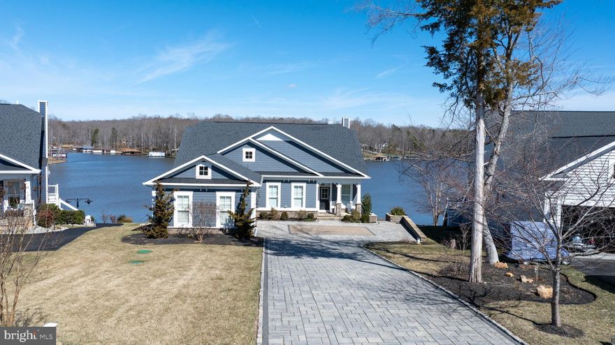 BE SURE TO CHECK OUT THE VIDEO! Stunning Modern Waterfront Lake House with Breathtaking Views! This designer-inspired waterfront property exudes elegance and modern living. Located in the highly sought after and amenity filled SUNSET COVE on the PUBLIC SIDE OF LAKE ANNA! Many furnishing to convey, making it easier for you to move in and start making memories! As you step inside, you're greeted by an open concept layout that seamlessly combines style and functionality. The heart of the home is undoubtedly the gorgeous gourmet kitchen, featuring high-end appliances, countertops and designer lighting that is sure to impress! The spacious family and dining area boasts a full 180 degree view of the shimmering lake! Notice the vaulted ceiling with wood beams, creating an airy and expansive feel. The gas fireplace with soaring stone accent serves as a focal point,  and beautiful engineered hardwood floors flow seamlessly throughout! Step outside to discover an expansive deck with live-edge wood bartop! Take the scenic walkway leading to the magnificent double decker boat house, ideal for endless summer fun! Head down to the lower level featuring a covered deck, sundeck, two boat slips with electric lifts. Did I mention two jet skis and the pontoon boat? Yes, all conveying as part of this incredible package.  Back inside, the primary bedroom is a tranquil sanctuary, offering great waterviews and a plush spa-like en suite. Additional bedroom, full bath, pantry, and convenient laundry room, to include washer/dryer and sink completes the main level. Upstairs, a delightful loft, with more water views, two bedrooms and a Jack-and-Jill bath means plenty of space for everyone! The lower level is a true entertainers dream, showcasing a lovely kitchenette featuring a kegerator, wine cooler, loads of cabinets and counter space, all adding to the modern feel. Enjoy movie nights, compete in a friendly game of pool, ping pong or darts. Additionally, there are two spacious bedrooms, each with well appointed bathrooms. Heading out to the patio expands even more entertainment options. Furnished with ceiling fans and heaters, for year around use. And don't forget the beautiful fire-pit, ready for your enjoyment, night after night! Let's not forget to mention the stone driveway, professional landscape, stone and boulder hardscape, surround sound, alarm, the list goes on. Let's talk about SUNSET COVE amenities. They include inground swimming pool, clubhouse, workout room, nature trails, pickleball, 14 foot boat launch, and lawn care! Also, your new home promotes a relaxed lifestyle WITHOUT THE INTERFERENCE OF  SHORT TERM RENTALS, ensuring a peaceful environment where you can truly unwind and connect with friends, family and neighbors! Don't miss your opportunity to make this beautiful retreat your own! Measurements are estimated.