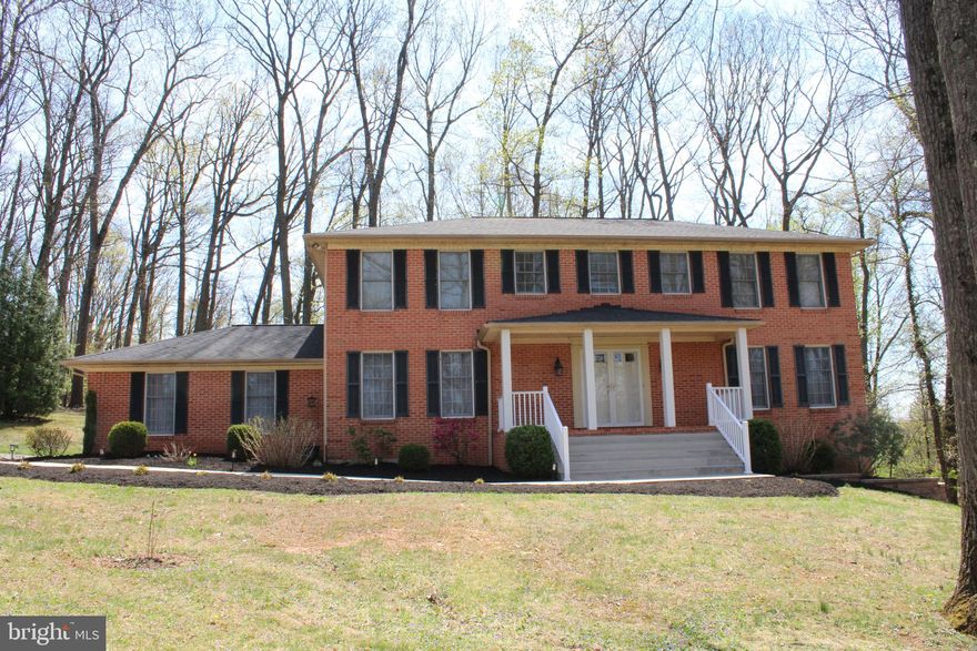 Welcome home to this beautifully updated 4-bedroom, 2.5-bath brick-front Colonial with a lovely front porch! Tucked away on a peaceful wooded lot, this home offers a great mix of comfort, space, and modern updates—perfect for everyday living.

Step through the double front doors into a welcoming foyer with a convenient half bath. The main level features stylish luxury vinyl plank flooring throughout (except the powder room), giving the space a clean, updated feel.
The recently remodeled kitchen is a true standout, featuring quartz countertops, stainless steel appliances, a stylish backsplash, bay window and recessed lighting—perfect for everything from casual weeknight meals to hosting friends and family. Just off the kitchen, the spacious family room offers a warm gathering space with a full-wall brick propane fireplace, wood mantel, and recessed lighting. A three-panel slider opens to a screened-in porch with a cathedral ceiling and ceiling fan, measuring 13' x 12', with additional adjoining decks (12' x 12' and 18' x 12')—perfect for relaxing or hosting outdoors. The dining room offers plenty of space for gatherings, complete with chair rail and crown molding, and the living room adds even more room to spread out, also featuring crown molding.

Upstairs, you’ll find four very large size bedrooms, including a comfortable primary suite with its own wood-burning fireplace, a beautifully updated bathroom with a spa-like shower, and a walk-in closet.
The lower level is ready for your ideas—whether you’re thinking about a home gym, movie room, or extra living space. If desired, the laundry room could be easily relocated to the lower level with hookups already in place.  A slider door and an additional exit door makes this lower level easily accessible. 

Major updates have already been done for you, including the kitchen (2025), water holding tank (2026), garage floor and deck staining (2024), hot water heater (2021), and roof, LVT flooring, primary bath, and radon remediation (2019). The home is also equipped with 400 amp service. 

If you’re looking for a move-in ready home in a quiet, natural setting, this one is definitely worth a look.
Come see it for yourself—you won’t want to miss it!  This property is perfectly situated within 1.5 miles of the Taylorsville intersection at (Routes 27 & 26), with easy access to both Frederick and Eldersburg.