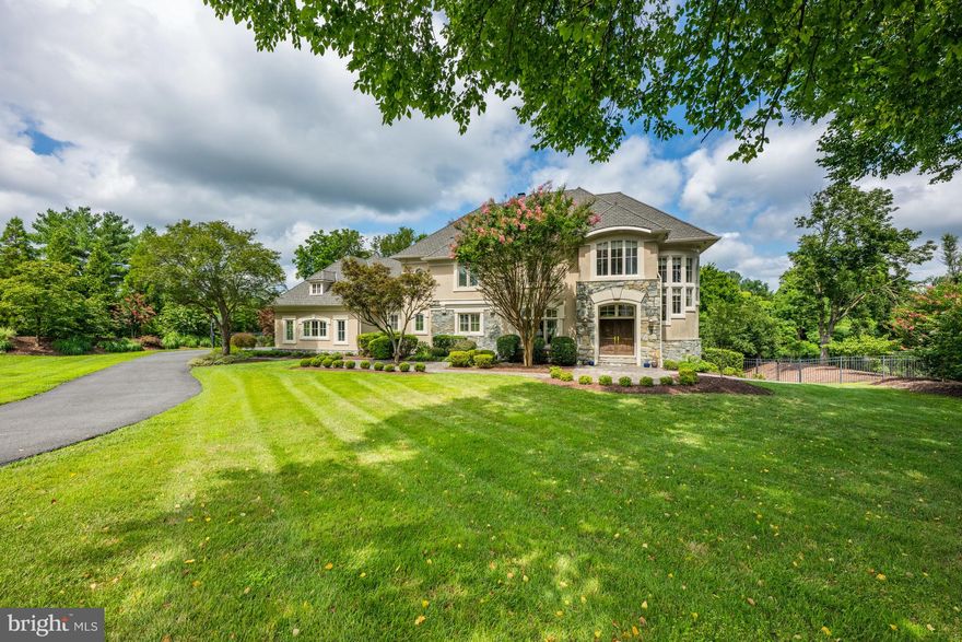 Award-winning builder Ted Visnic created this stunning stone-and-stucco custom home. Located on a private tree-lined street just minutes from Potomac Village, this immaculate and extremely well-maintained home is situated on two beautifully landscaped acres.
The main level features a soaring, two -story Foyer with circular staircase with windows, custom chandelier. and balcony  overlook. The  Living Room with coffered ceiling, and stone floor-to- ceiling gas fireplace, the Dining  Room with pillared entry and the private Study are  easily accessible from the Foyer. The huge  Chef's Kitchen with center island with seating, has granite countertops and light stained wood cabinets, Viking range with hood, SubZero floor-to-ceiling refrigerator  and separate freezer . The Family Room/ Eating Area  features a desk, stone gas fireplace and sliding glass doors to Terrace . The large Mud Room adjacent to the Kitchen has an informal Powder Room,  Laundry Room, closet and provides easy access to the three car side entry garage.
Four bedrooms grace the upper level each with ensuite bathrooms. The Primary Suite has a spacious Primary Bedroom with a tray ceiling with recessed lighting,  a  window seat with  windows and an atrium door which leads to a Juliette Balcony  overlooking the backyard and pool. The Primary Bathroom has dual sinks, separate tub and shower and also has a Juliette Balcony overlooking the pool.
The finished walkout Lower Level provides additional options for a myriad of uses. A large Recreation Room with separate tablespace, a Home Theater with stadium seating, a gym with extra storage space,   a Fifth Bedroom with ensuite full bathroom plus an additional full bathroom and changing closet complete the lower level. 
This distinctive home shows like new with newly added dual HVAC zones and thermostats, stereo system throughout, detailed moldings, custom walnut flooring,  and exterior lighting.
With fabulous indoor and outdoor spaces this is truly a home for a lifetime.