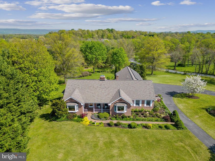 Custom built 4 bedroom, 3.5 bath brick rancher located on more than 2.5 acres of land, backing to trees, outside of Shepherdstown. When you step onto the front porch you will see this home speaks of craftsmanship and care in both the construction and the design. Fully equipped with Andersen windows, 36 solar panels with back-up battery, and a fully finished basement, this home would justify all the superlatives. The expansive primary suite with sitting area overlooks the rear deck, the gardens, and boasts a luxurious en suite bath. The living room is flanked with multiple glass doors to bring in light and access the deck, the gardens, and the vista. Stained glass details shine down, and the vaulted ceiling leads the eye to the gleaning enamel cast iron wood stove. The updated eat-in kitchen likewise gleams with quality–solid wood cabinets, high-end stainless-steel appliances, sleek stone counters and opens to a breakfast room with a broad bow window. There is a separate formal dining room as well. Past the kitchen, is the powder room and the convenient laundry room. Beyond that are two spacious, light-filled bedrooms that face the hall bathroom. Towards the garage, the stairs lead down to the finished basement with a spacious family or TV room, and a full bedroom suite with an attached full bath, separate exterior access and adjoining sitting room. The huge garage houses three full bays, additional work or gardening space, utility sink and doors to access both the front and back yards. There is a shed at the end of the garden and exterior motion activated lights on the property. *** Architectural shingle roof replaced in 2019 and has a 30-year transferrable warranty. Close to all the cultural amenities of Shepherdstown, this home is a beautiful sanctuary in the country.