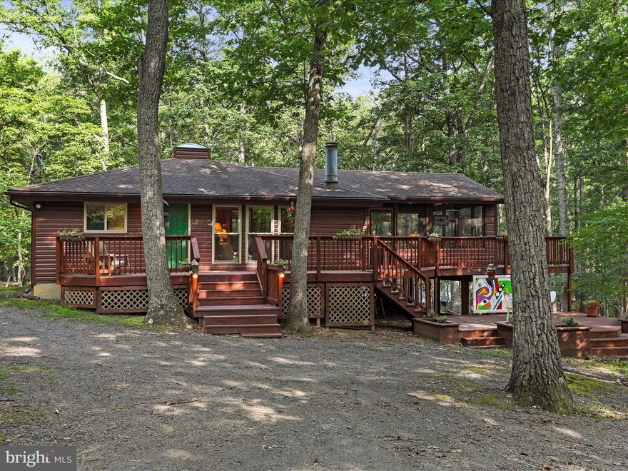 Back to active pending signed release.

Artful Escape on Mild Winter Road
127 Mild Winter Rd | $379,900 | 3BR | 2BA |  1,024 Sq Ft | Class A Membership Included

Nestled beneath a canopy of mature hardwoods, this inspired mountain retreat blends rustic charm with artistic spirit—a home that feels both carefully curated and effortlessly livable.

Set on a beautifully wooded lot, the property underwent a thoughtful transformation just three years ago:

- New HVAC system for year-round comfort
- New windows, and sliding door to invite light and forest views
- New log-style siding, accented by a new welcoming front door
- Interior repainting throughout for a fresh, cohesive backdrop
- A rebuilt deck system and 18x18 screened-in porch that embrace the outdoors with intention

Step inside to a beautifully remodeled kitchen where quartz countertops, stainless steel appliances, and luxury vinyl plank flooring meet style and utility. Over the counter, remote-controlled pendant lighting shifts colors with the tap of a button—casting a warm glow for everyday meals or setting the mood for evening gatherings.

The open-concept living and dining space is anchored by a wood-burning fireplace, framed by a soaring vaulted ceiling adorned with two 8-foot original art panels, created by the seller and offered as part of the home’s unique character.

Plush carpeting carries throughout the bedrooms and living spaces, adding comfort underfoot and reinforcing the home’s easy, relaxed rhythm.

The primary suite features a vaulted ceiling, a thoughtfully placed awning window ideal for bed placement, and a four-piece bath with an added window to invite natural light. Two guest bedrooms—each with vaulted ceilings—share a second full bath, creating a balanced and functional layout.

Outdoor living is as inspired as the interior. A ground-level deck offers space for dining, lounging, or quiet evenings around a firepit. As a backdrop, a custom outdoor art piece, also created by the seller, will convey—an artistic exhale in a serene woodland setting.

Furniture can convey at no cost, excluding select antique pieces, art, and personal items.

A Class A Membership to The Woods Club is available, providing access to golf, indoor/outdoor pools, tennis, fitness facilities, and more. The one-time initiation fee is $3,150, and annual dues are $2,600.