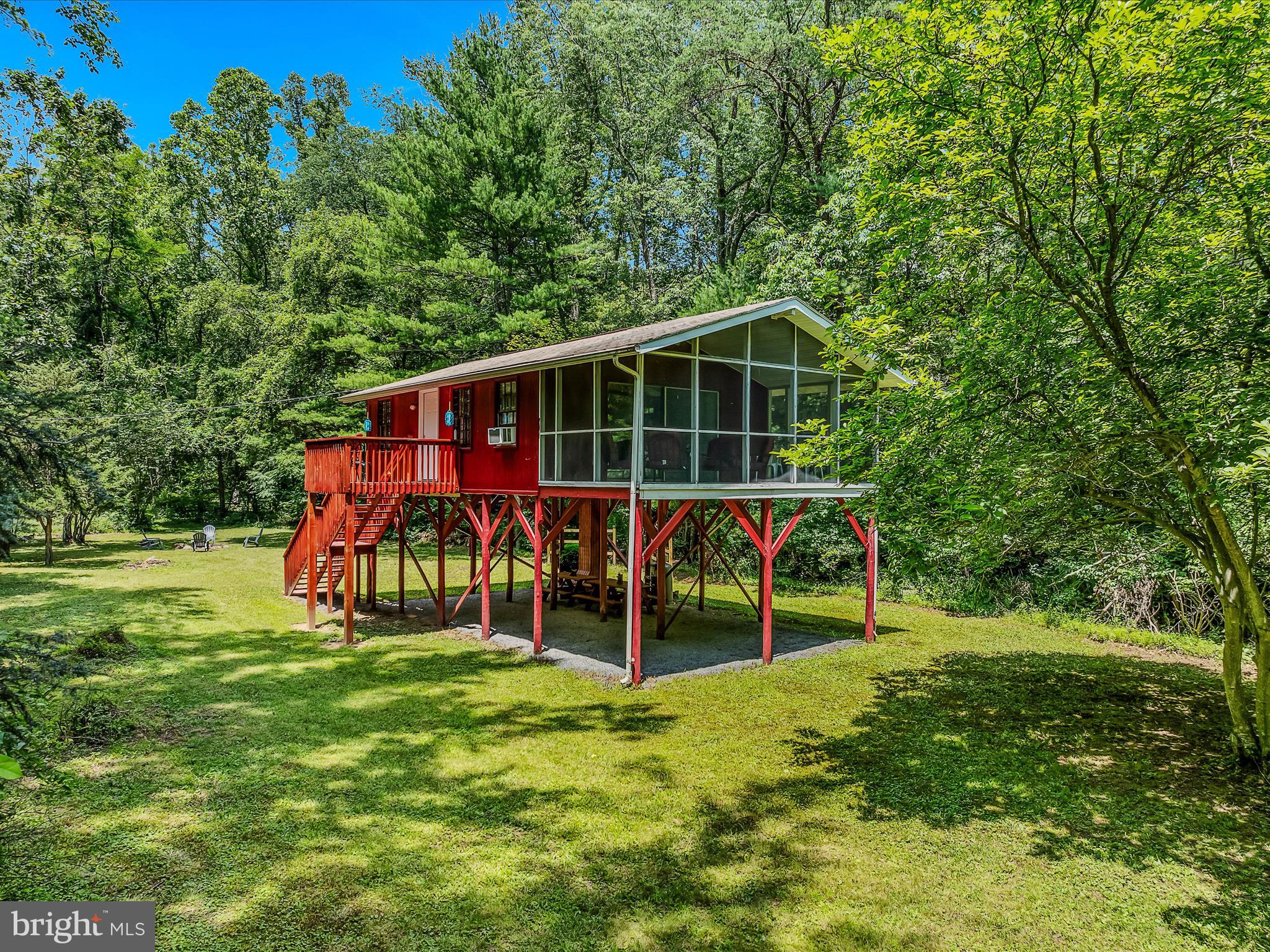 Retro Riverfront Retreat on the Cacapon – Private Access & Peaceful Seclusion!
Imagine escaping to your own private riverfront getaway—complete with direct access to the scenic Cacapon River—at a price that won’t break the bank! This cool, retro refurbished cabin offers the perfect blend of charm, comfort, and outdoor adventure on 2.95 gated acres.
Inside, you’ll find a smart and cozy 540 sq ft layout featuring a bedroom area, full bath, and an open-concept kitchen, dining, and living space. Step out onto the 200 sq ft screened-in porch and let the sounds of nature take over while you relax, dine, or unwind.
Down below, the cabin’s open-air underside is outfitted with fresh gravel and lighting, making it an ideal patio-style space—perfect for storing kayaks and gear or enjoying the picnic tables or add your own outdoor furniture. A firepit is already in place, waiting for evenings filled with stories and s’mores.
Follow the marked path with new steps down to your very own private river access—perfect for fishing, swimming, or launching a canoe. The wooded surroundings provide just the right amount of seclusion while offering plenty of open space to host friends or enjoy the ultimate riverside camping experience.
Don’t miss this rare chance to own a slice of river paradise with endless possibilities—schedule your private showing today!
HOA DOES NOT ALLOW SHORT TERM RENTALS. HOA MAINTAINS THE ROADS WITH GATES AND LOT WITH BOAT RAMP. HOA FEE IS $75/LOT. PROPANE TANKS FOR COOKING-LEASED THROUGH BLUE FLAME. CURRENT FLOOD INSURANCE IS $1100/YEAR
