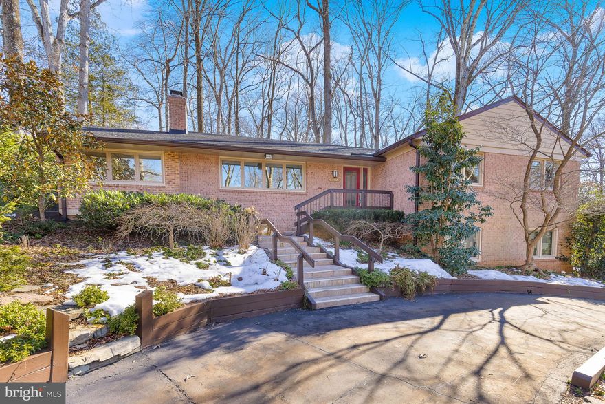 LAKE BARCROFT - Expansive & Updated 4BR/3BA Mid-Century Modern, 1 Block to Beach!

Enter through the beautiful stained-glass door into this warm, welcoming home filled with natural light flowing through the large windows, gleaming hardwood floors, and custom wood trim.

The living room shares a double-sided gas fireplace with the cozy den boasting built-ins and a sliding glass door opening to a private patio. The dining room overlooks the serene private landscaped backyard. The updated eat-in kitchen shines with stainless steel appliances, granite countertops, and a large breakfast nook. Sliding doors open to the sunroom and multi-level slate patio. The main level also includes four bedrooms and two bathrooms, including the en-suite primary.

The lower level offers an oversized family room with a gas fireplace, sliding doors to the lower patio, and direct garage access. This level also includes a large room perfect for an office or home gym, a bonus room, a full bathroom, and a large laundry room. Both the laundry room and attic offer loads of storage.

Nestled on a beautifully landscaped one-third acre lot, this home features extensive hardscaping, outdoor lighting, and a lush array of mature trees, flowering plants, and shrubs. Parking is effortless with an attached 2-car garage and an expansive semi-circular driveway.

Located just a block from one of Lake Barcroft's five private beaches for swimming, boating, and fishing, this home also offers easy access to major commuter routes (50/66/395/495) and is just minutes to Tysons, Arlington, and Washington, DC.