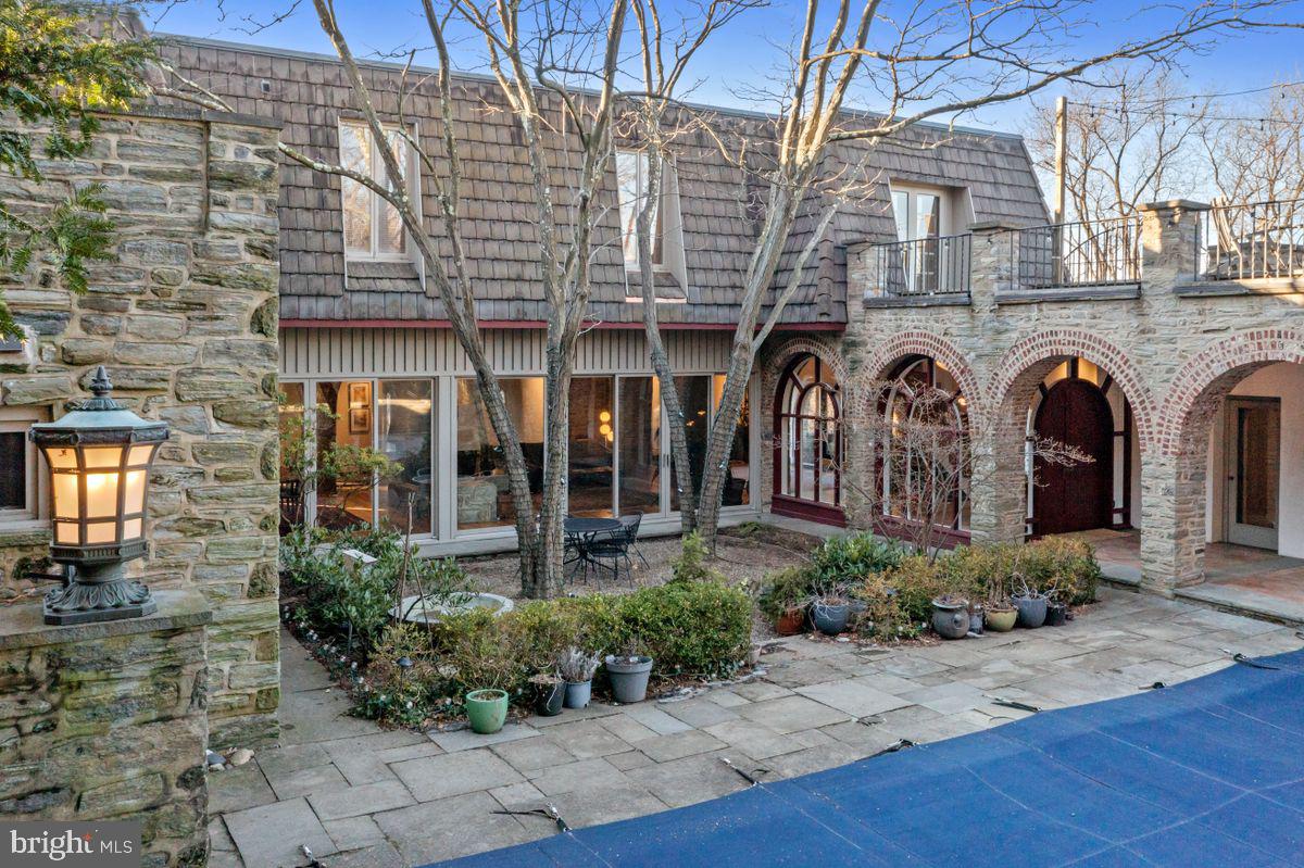 Welcome to "Greystock" at 7 Caryl Lane. Indeed one of the most private and desirable walkable locations in Chestnut Hill. An exquisite residence, designed and built in 1880 by Theophilus Chandler, is a true architectural treasure, meticulously updated and maintained. They say it's all in the details, and you will love every one of them in this fabulous home, beautifully sited on just under an acre. The open floor plan offers 5000+ square feet, five bedrooms, two full and one-half baths. The grand entry hall opens to the living room, dining room, and library/family room. Gourmet kitchen features original Wissahickon schist, custom cabinets, gleaming granite countertops, and a Thermador/Miele/Bosch appliance package completes the open floorplan perfect for everyday living and entertaining. The lower level offers approximately 800 square feet of additional finished space perfect for a gym, office, or playroom. Upstairs, the primary suite features a luxurious bath, dressing room, walk-in closet, and a stargazer's dream roof deck: four additional bedrooms and two baths and working/living spaces. An additional large deck is natural for entertaining. Soaring 9+ foot ceilings, hardwood floors throughout, oversized windows and doors. Outstanding outdoor with lovely flagstone terraces and a pool. Opportunity awaits with this rare combination of midcentury and late 1800 century bones reimagined thoughtfully with today's world in mind. With a coveted location, walkable to schools, shops, restaurants, public transportation, and the Wissahickon Trails, 7 Caryl Ln offers one of Chestnut Hill's most unique and reimagined properties.