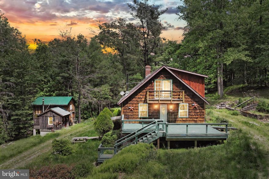 A Private Homestead Retreat with Rental & Business Potential — Just Behind Liberty Mountain Resort

Welcome to this one-of-a-kind 13-acre retreat tucked away just minutes behind Liberty Mountain Resort. With three homes, multiple outbuildings, and wide-open space for your vision to come to life, this property offers the rare opportunity to live, work, and invest all in one place.

At the heart of the property sits the main residence — a warm and welcoming 5-bedroom, 2.5-bath home featuring hardwood floors, a cozy fireplace with mantel, convenient first-floor laundry, and a main-level bedroom with ensuite bath and private entrance — perfect for guests or multi-generational living. Step outside to enjoy the peaceful setting from one of the multiple decks and balconies overlooking the woods and creek.

Two additional homes on the property offer incredible potential — whether you're dreaming of Airbnb rentals, long-term tenants, or space for extended family. With a little vision and TLC, they could become cozy income-producing units or guest houses.

For those looking to run a home-based business or need serious workshop space, the Morton building is a standout. Fully insulated and heated with its own garage and covered concrete driveway, this large structure was once home to a clock repair shop and store. With full utilities in place, it’s ready to be repurposed for your next venture.

Additional outbuildings include two large hangar-style garages, a working shed, and a separate wood house with a furnace room — ideal for homesteaders, hobbyists, or anyone needing serious storage and utility space.

The land itself is a nature-lover’s dream: wooded, private, and complete with a peaceful creek where you can cast a line and catch fish. Horses and livestock are welcome here, and there’s even a buildable site in the back corner of the lot if expansion is in your future. Access is chained by a charming bridge crossing the creek — ensuring peace, privacy, and security.

Whether you're seeking a private rural getaway, an income-generating property, or the perfect canvas to build a self-sufficient lifestyle — this property has the space, the setting, and the soul to bring it to life.